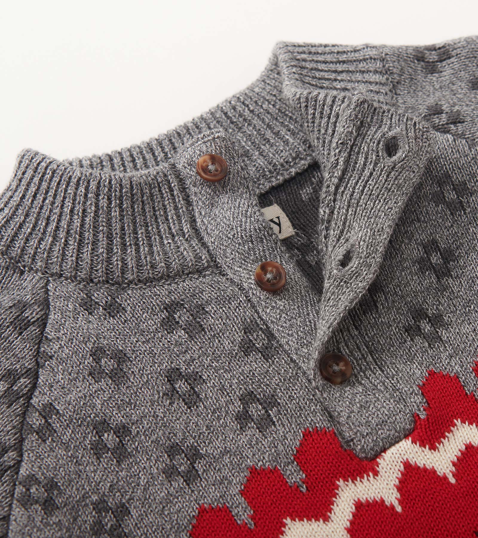 Gray mockneck sweater with a patterned design and red accents, featuring button details at the collar.