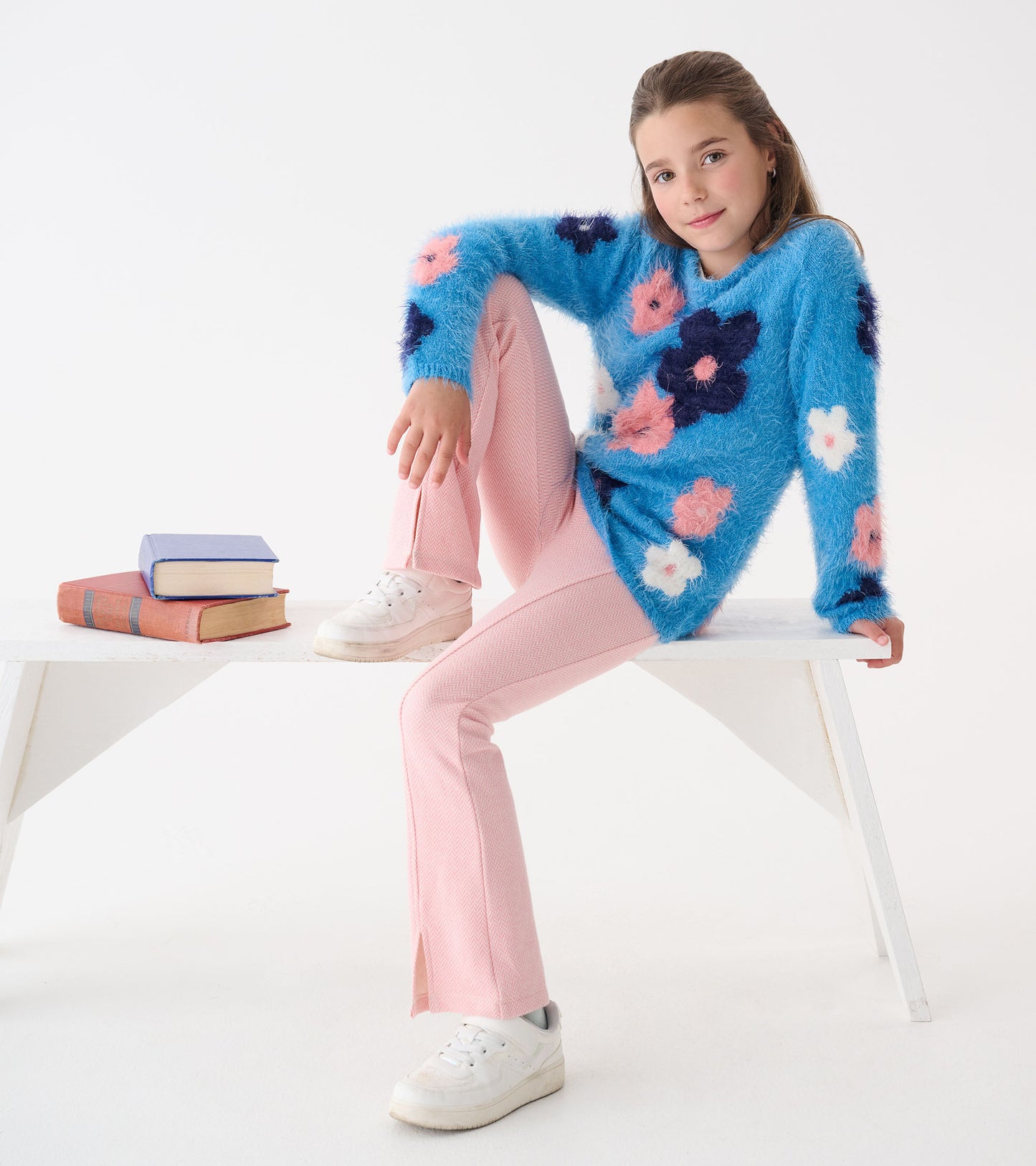 Furry blue sweater with pink and navy floral patterns, paired with pink pants and white sneakers, styled casually.