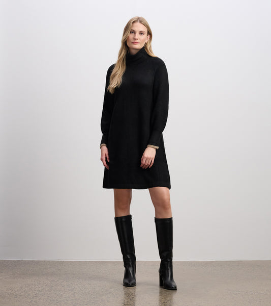 Black swing sweater dress with a high neck and long sleeves, styled with knee-high black boots.