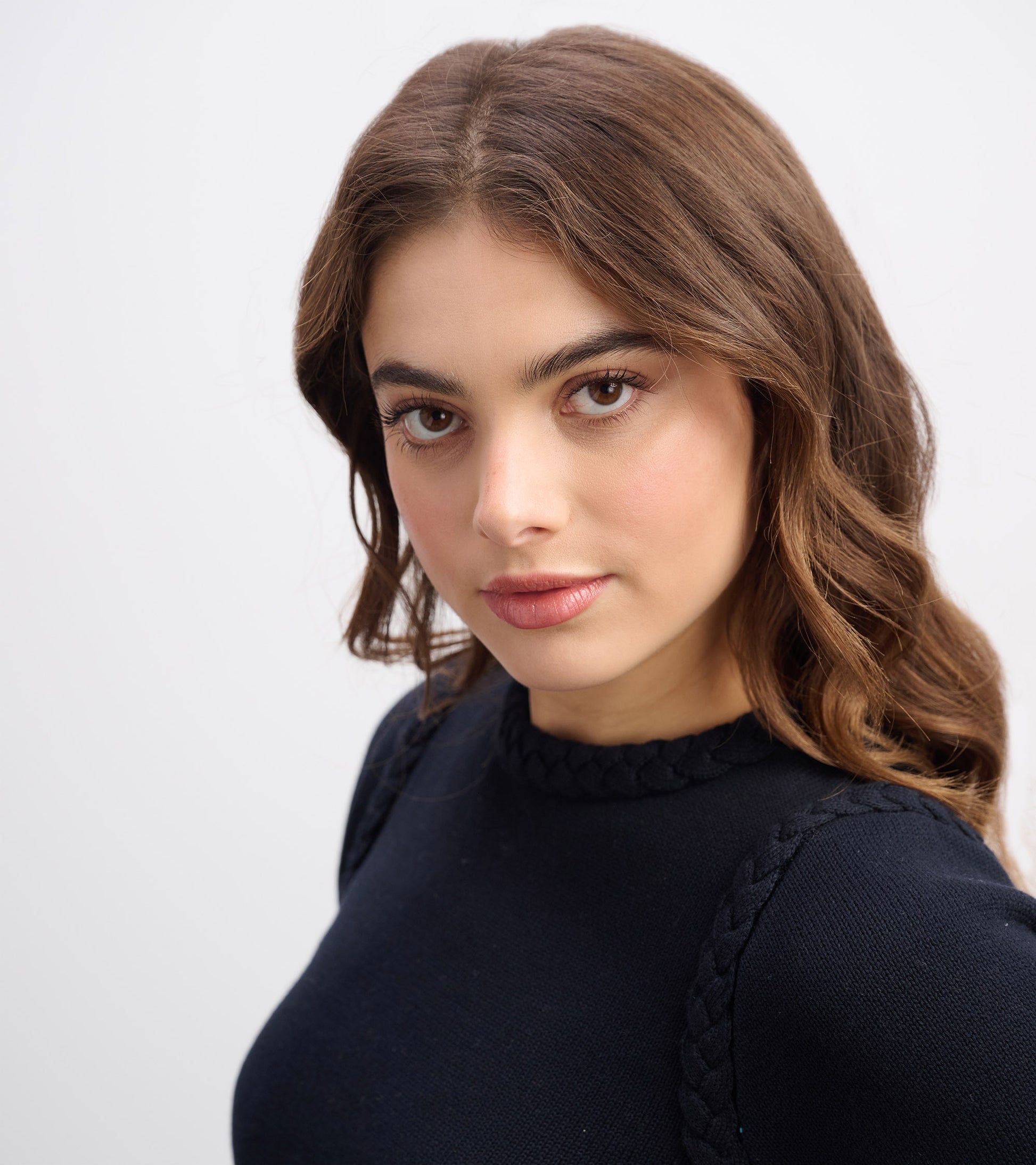 Black braided sweater with a round neckline, featuring textured detailing on the shoulders. Suitable for casual wear.