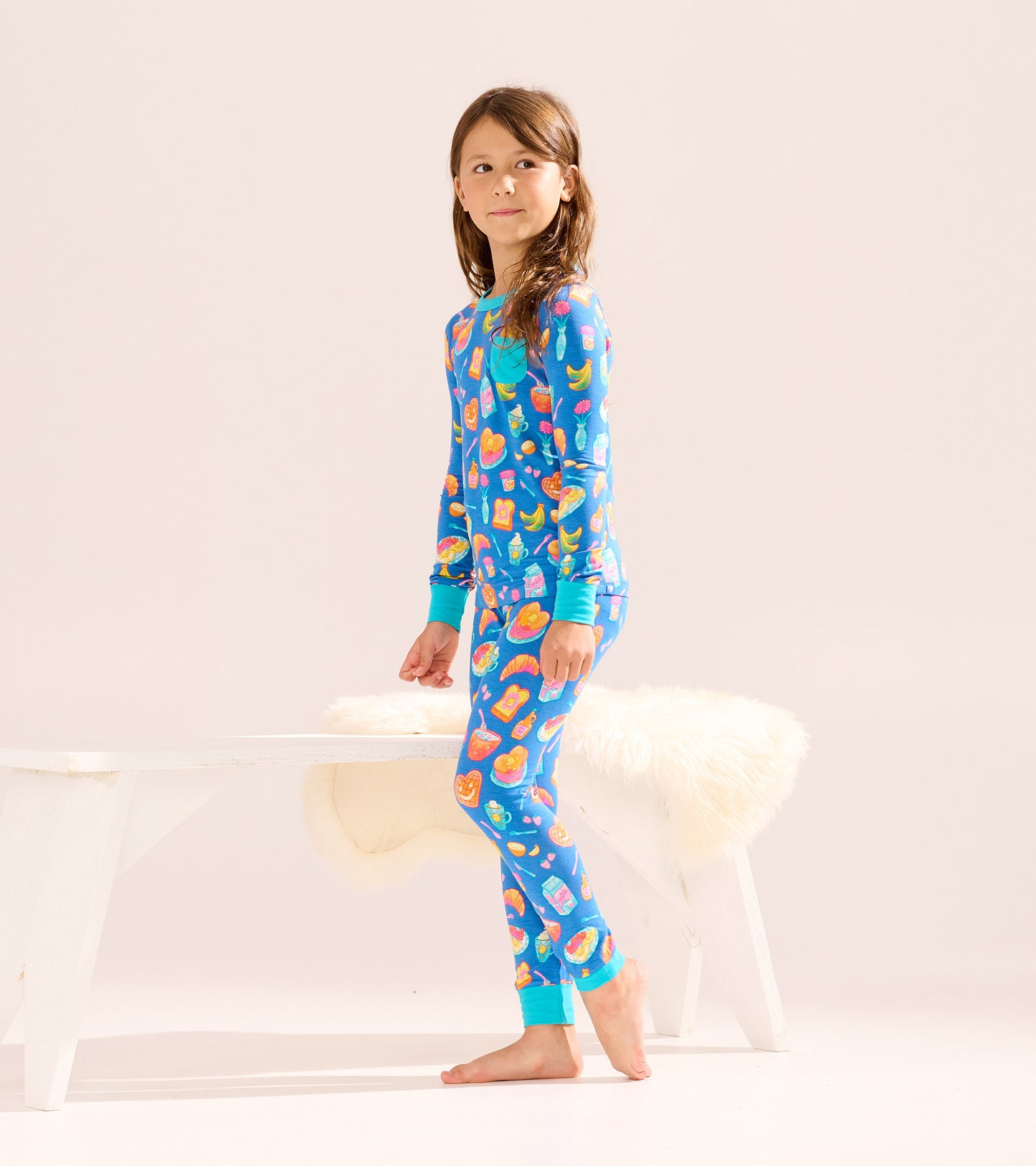 Blue bamboo pajama set for girls featuring colorful breakfast food prints, long sleeves, and matching cuffs.