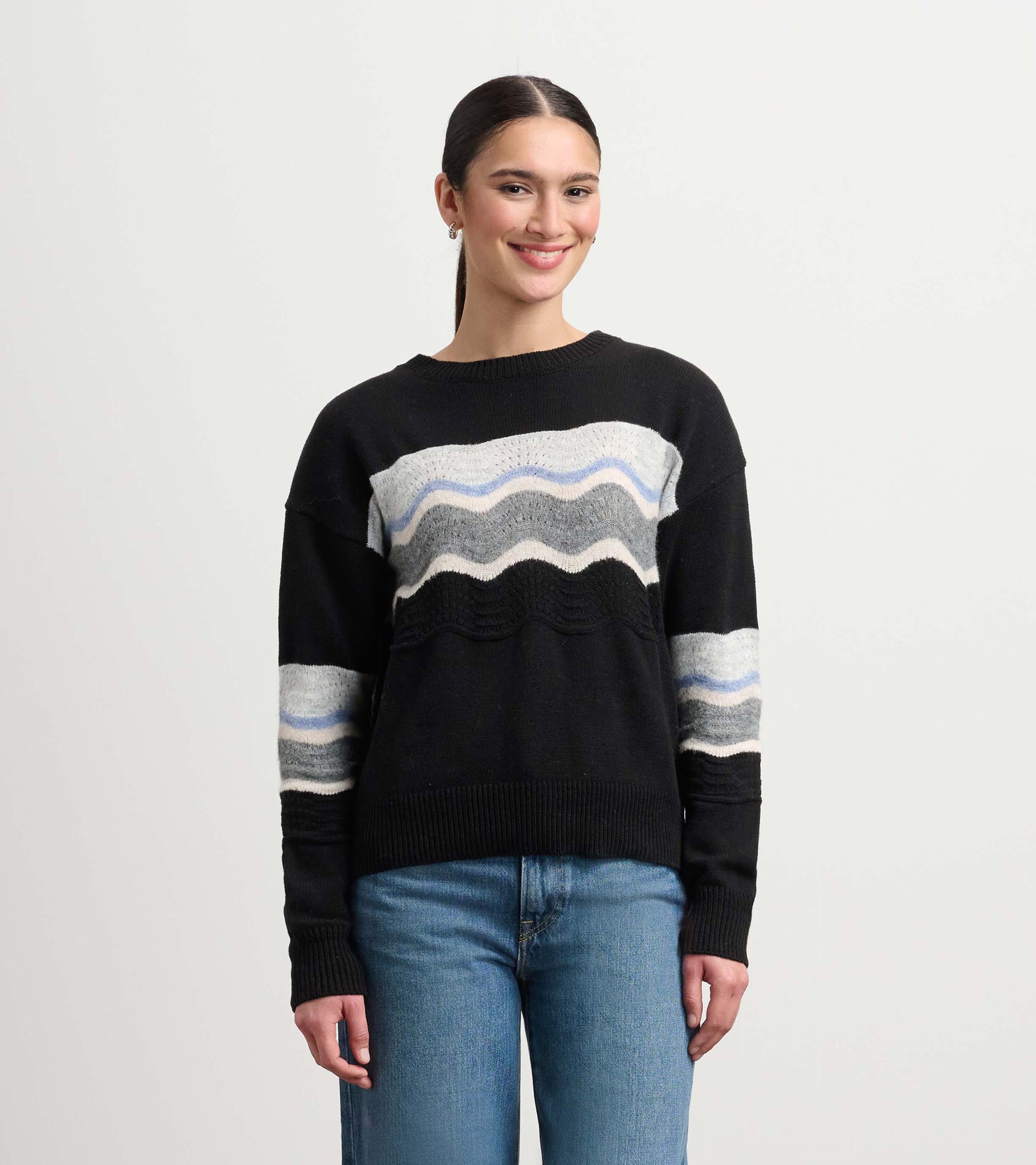 Black pointelle sweater featuring a wavy pattern in gray and blue, styled with relaxed fit and long sleeves.