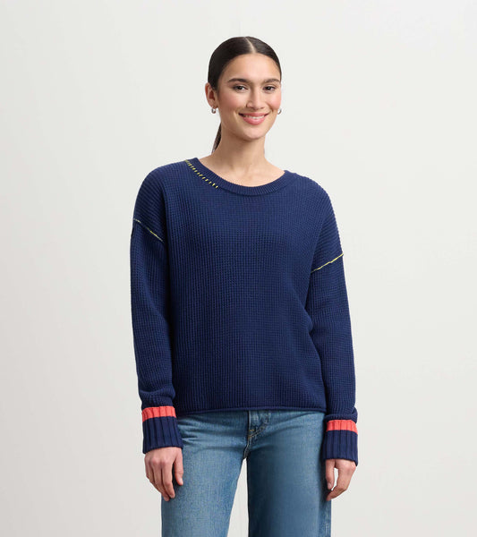 Navy waffle knit sweater with contrasting coral and yellow detailing, featuring a relaxed fit and long sleeves.