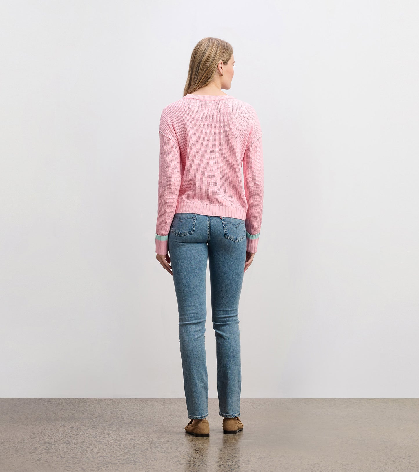 Fuchsia pink waffle knit sweater with long sleeves and contrasting cuffs, shown from the back.
