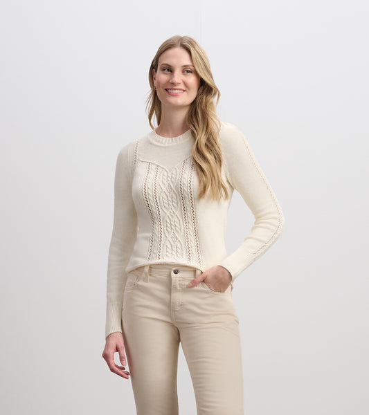 Cream sweater featuring a textured knit pattern and a fitted silhouette, worn with light-colored pants.