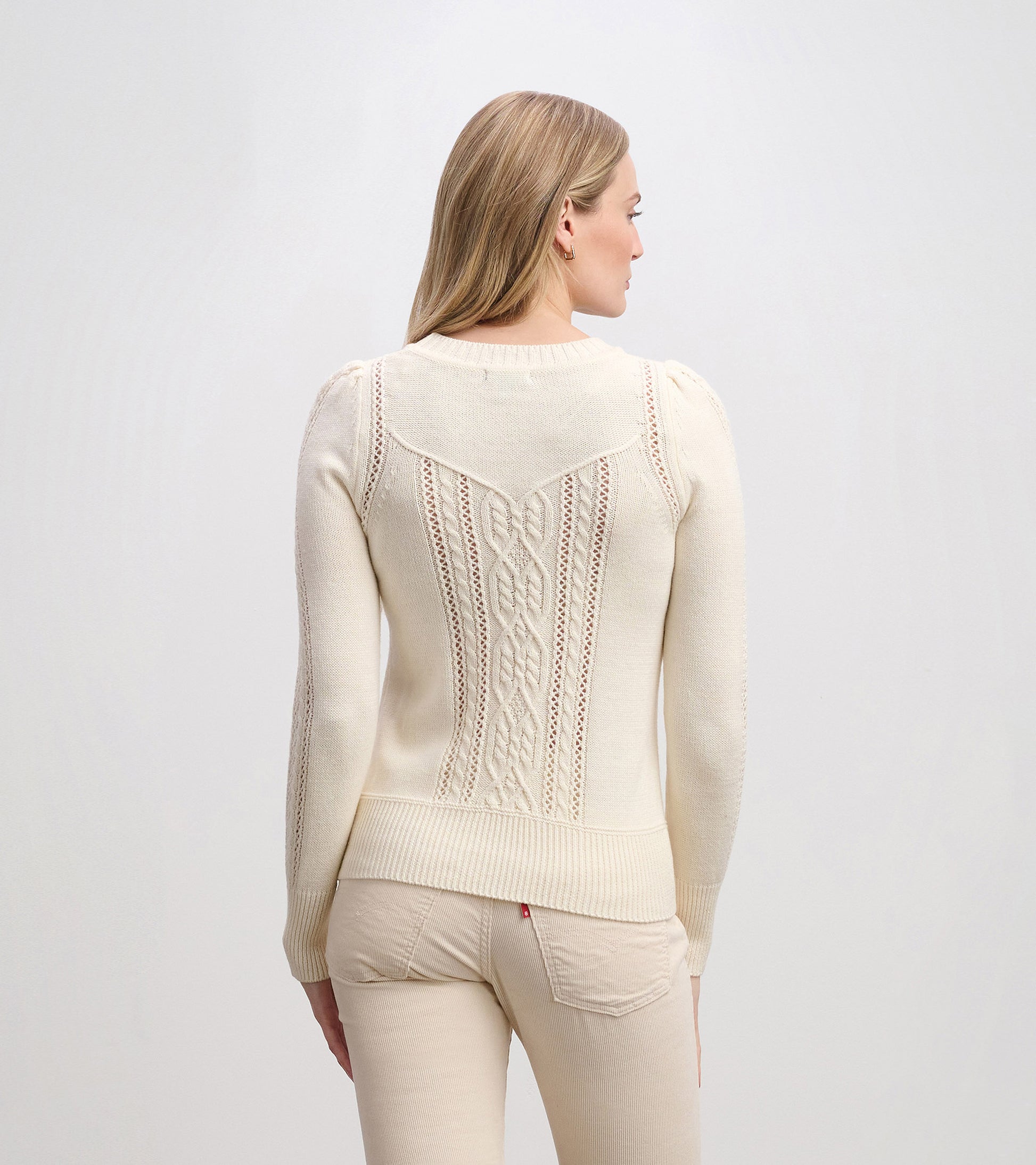 Cream sweater featuring a textured knit pattern and a fitted silhouette, viewed from the back.