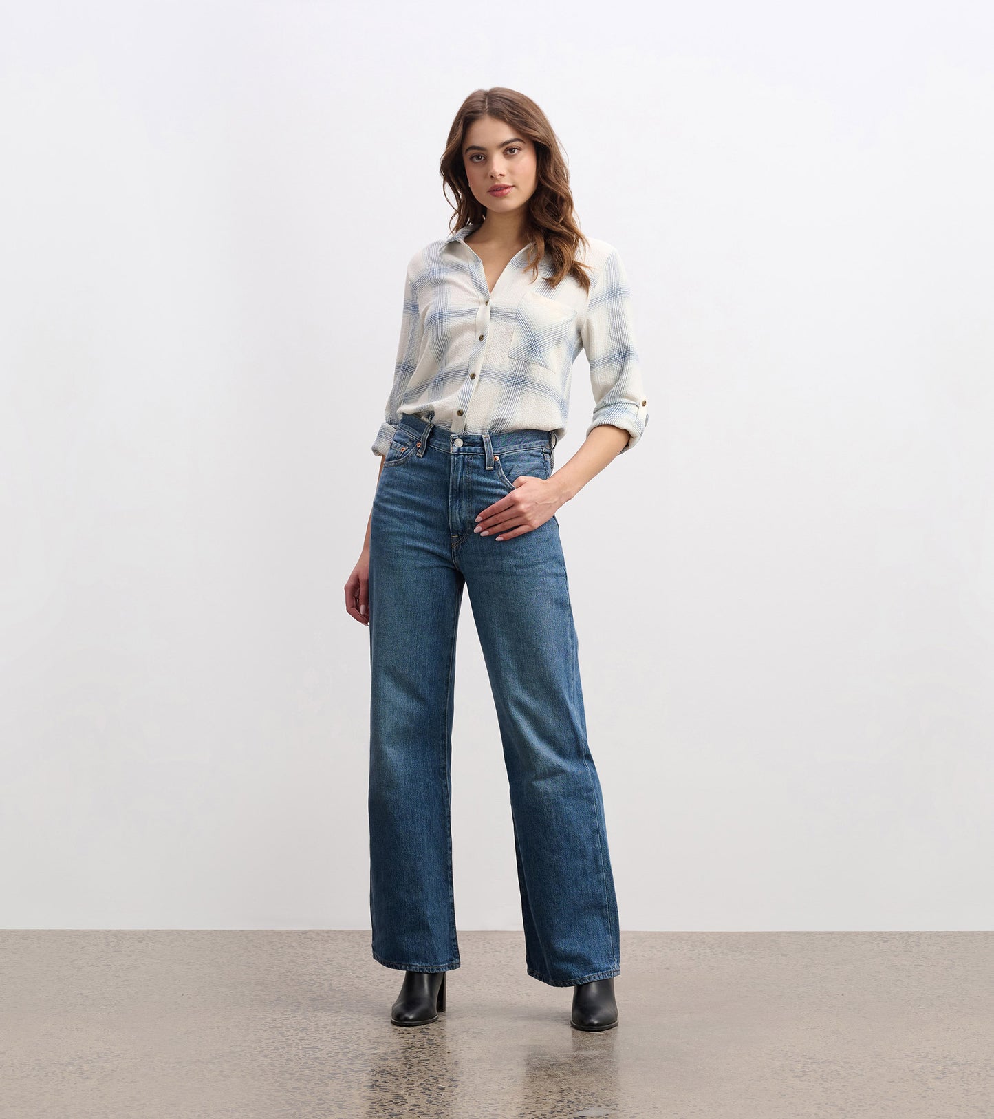 Turquoise plaid button-down shirt with a relaxed fit, paired with high-waisted blue jeans and black ankle boots.