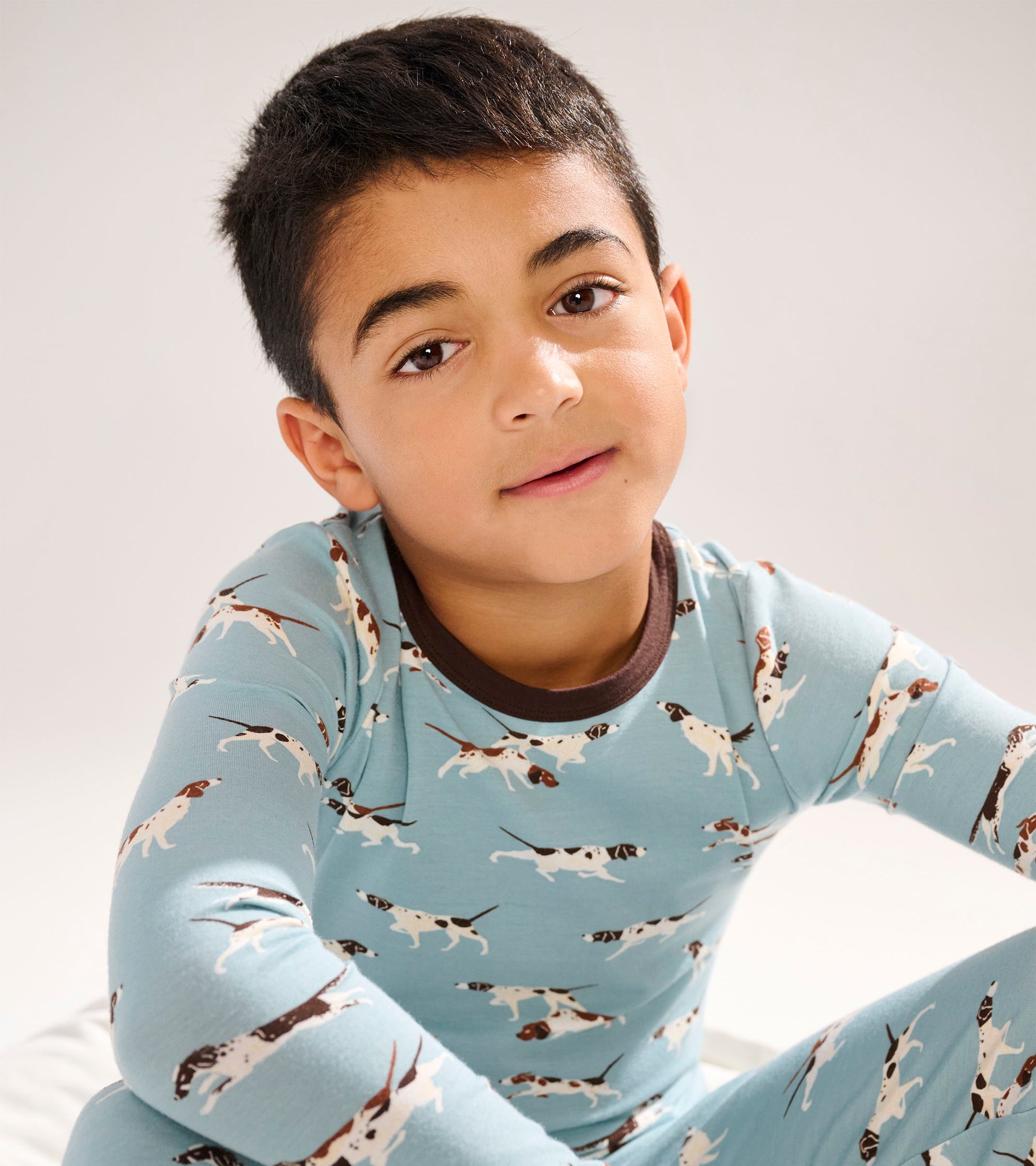 Light blue bamboo pajama set featuring playful hunting dog patterns, with a brown neckline and cuffs.