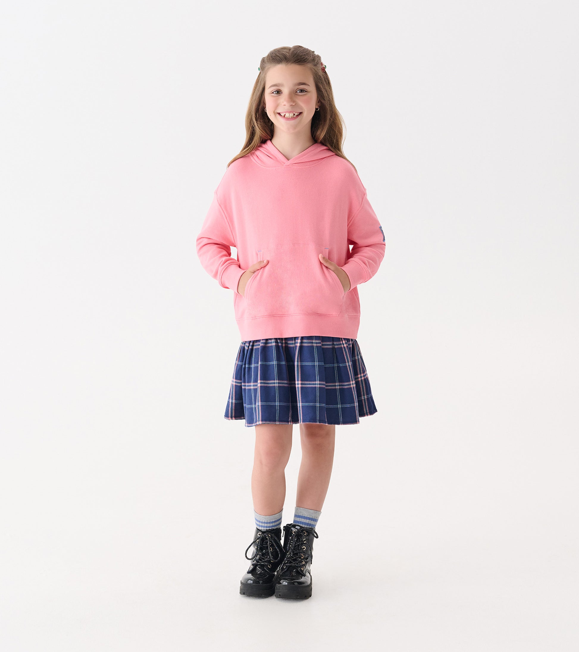 Pink hoodie with front pockets paired with a navy plaid skirt, suitable for casual wear.
