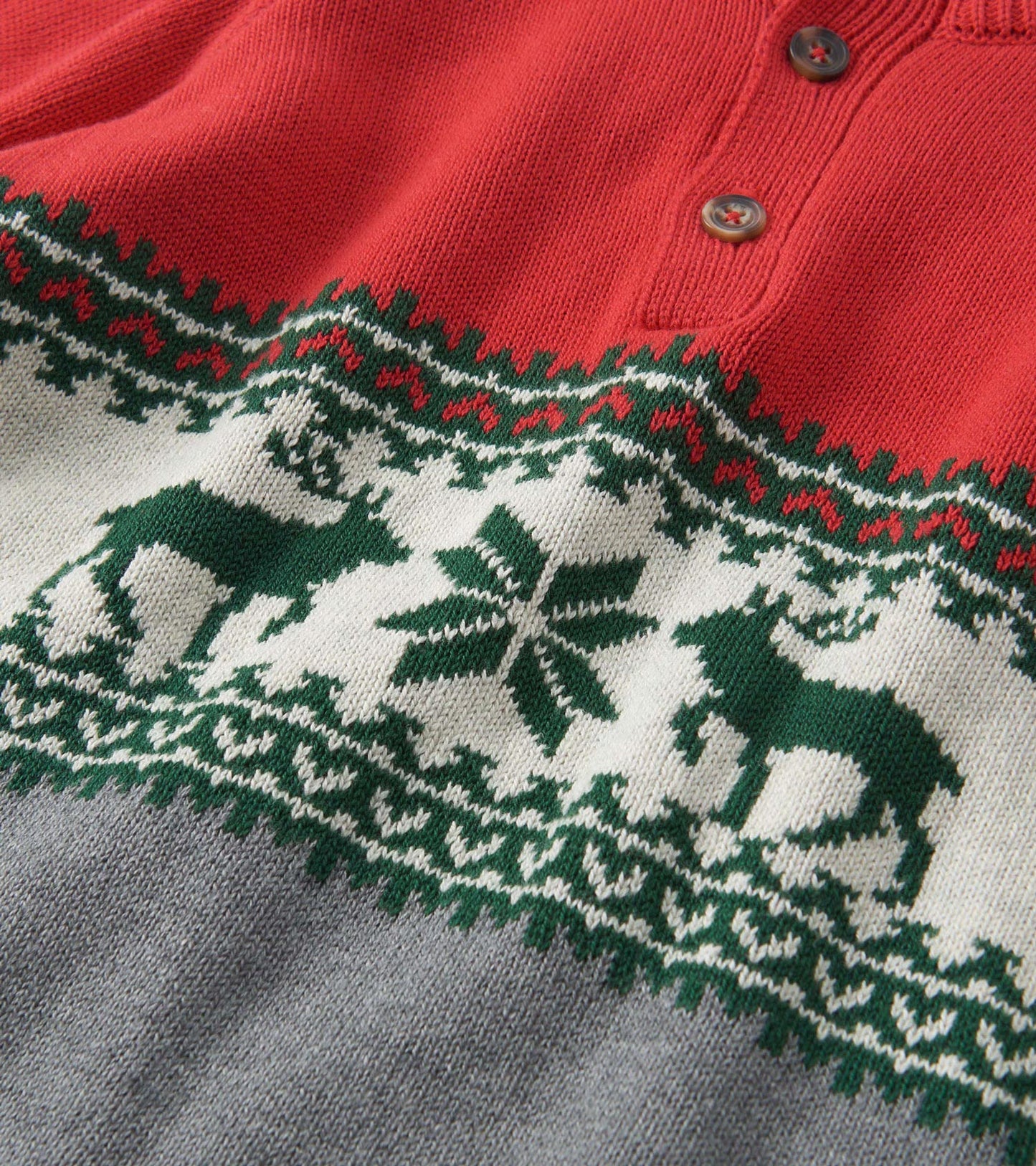 Red mockneck sweater featuring a festive elk and snowflake pattern in green and white, with a gray lower section.