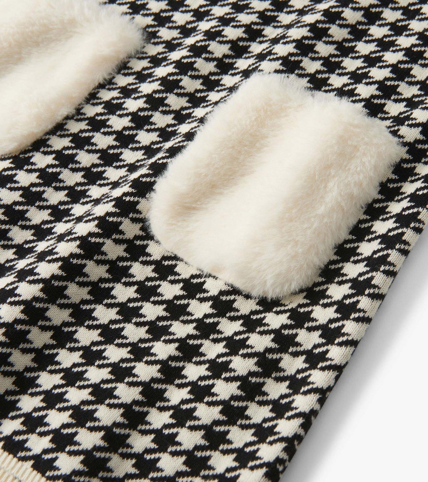 Black-and-white houndstooth sweater dress with cream faux fur pockets, close-up detail