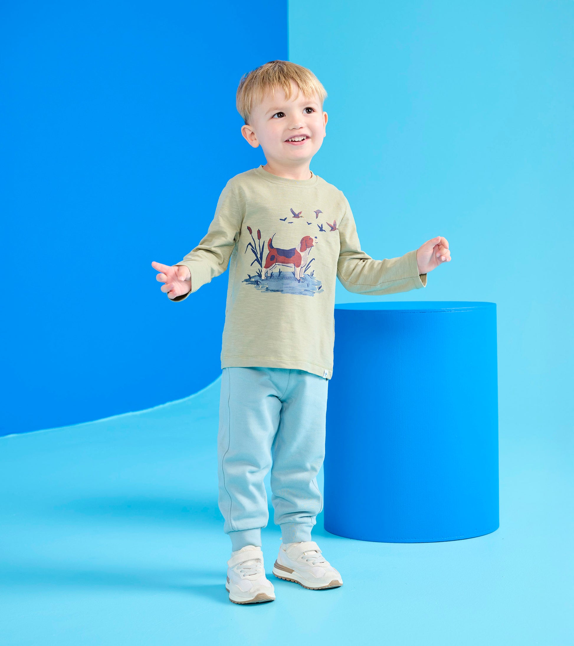 Light green long-sleeve shirt with hunting dog graphic, paired with light blue sweatpants and sneakers.