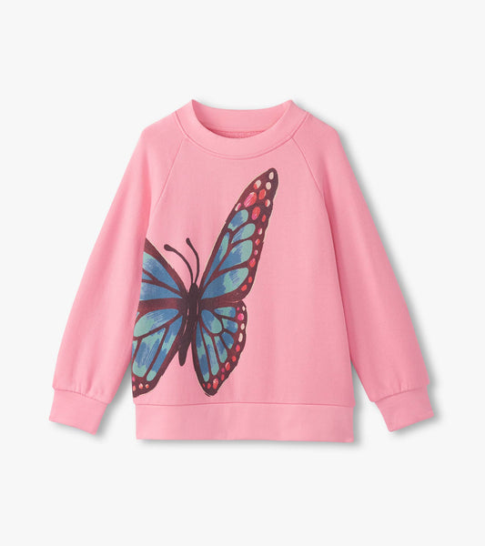 Pink slouchy pullover featuring a large blue butterfly graphic on the front, with long sleeves and a round neckline.