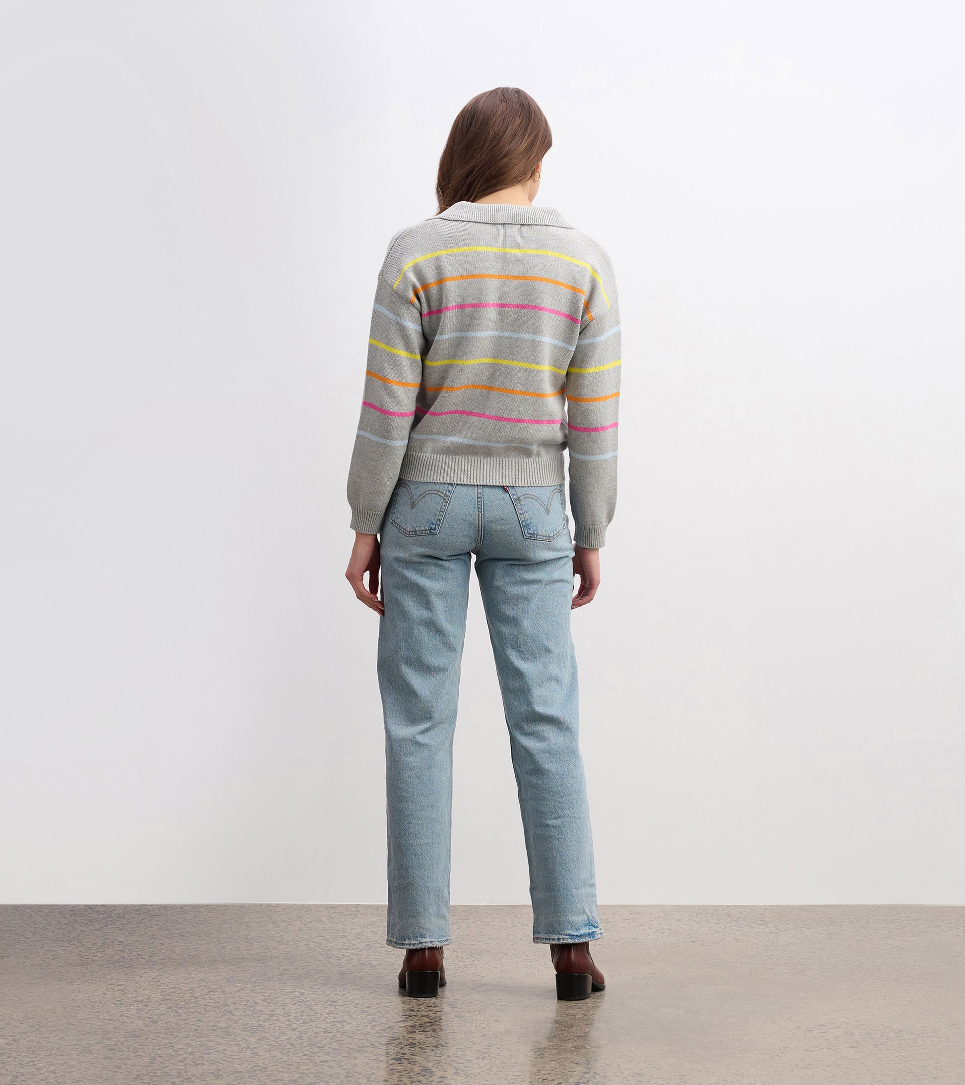 Gray sweater with sorbet stripes, featuring a collar and ribbed hem, worn with light blue jeans, viewed from the back.