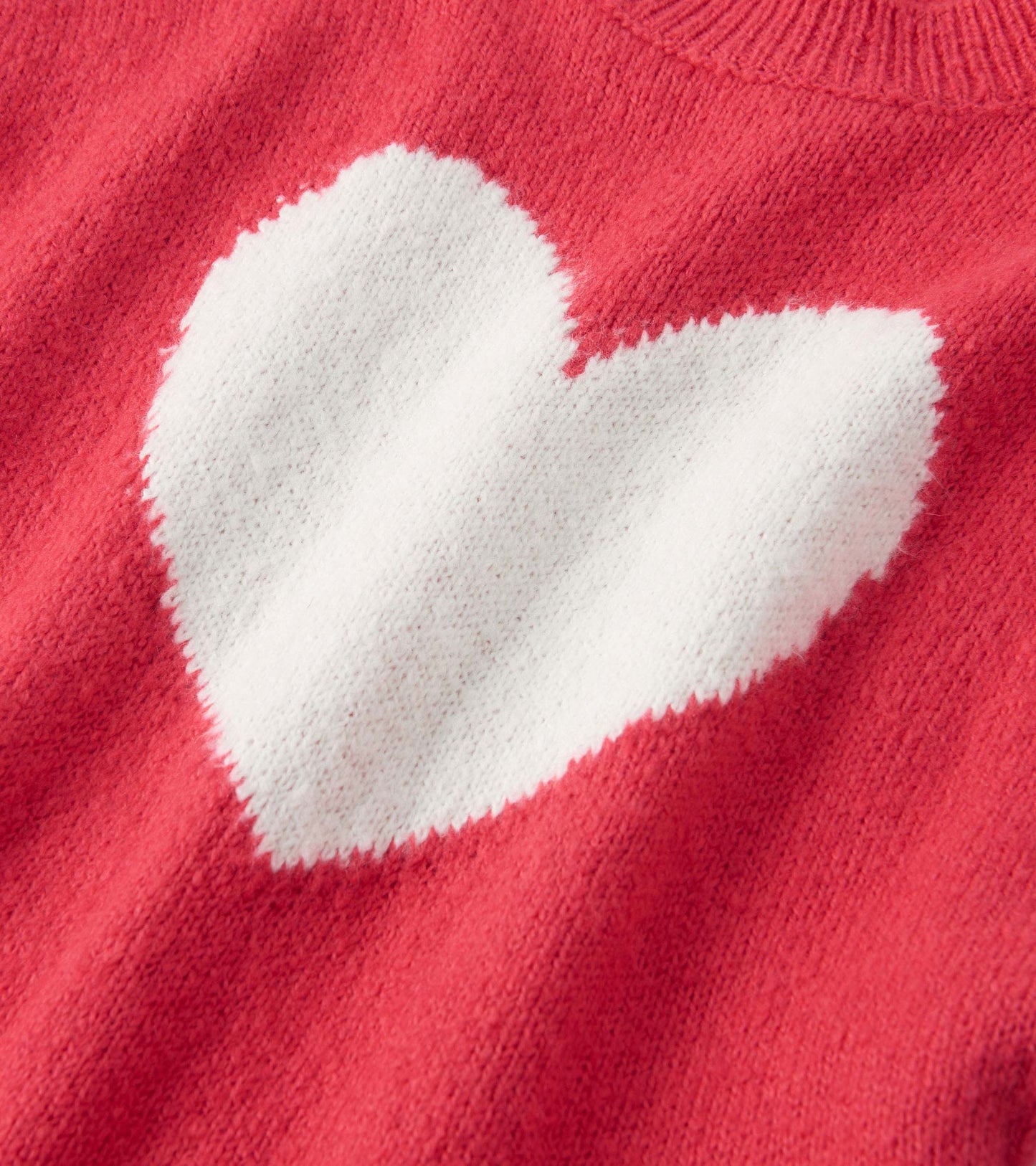 Red sweater vest featuring a large white heart design, made from soft knit material.