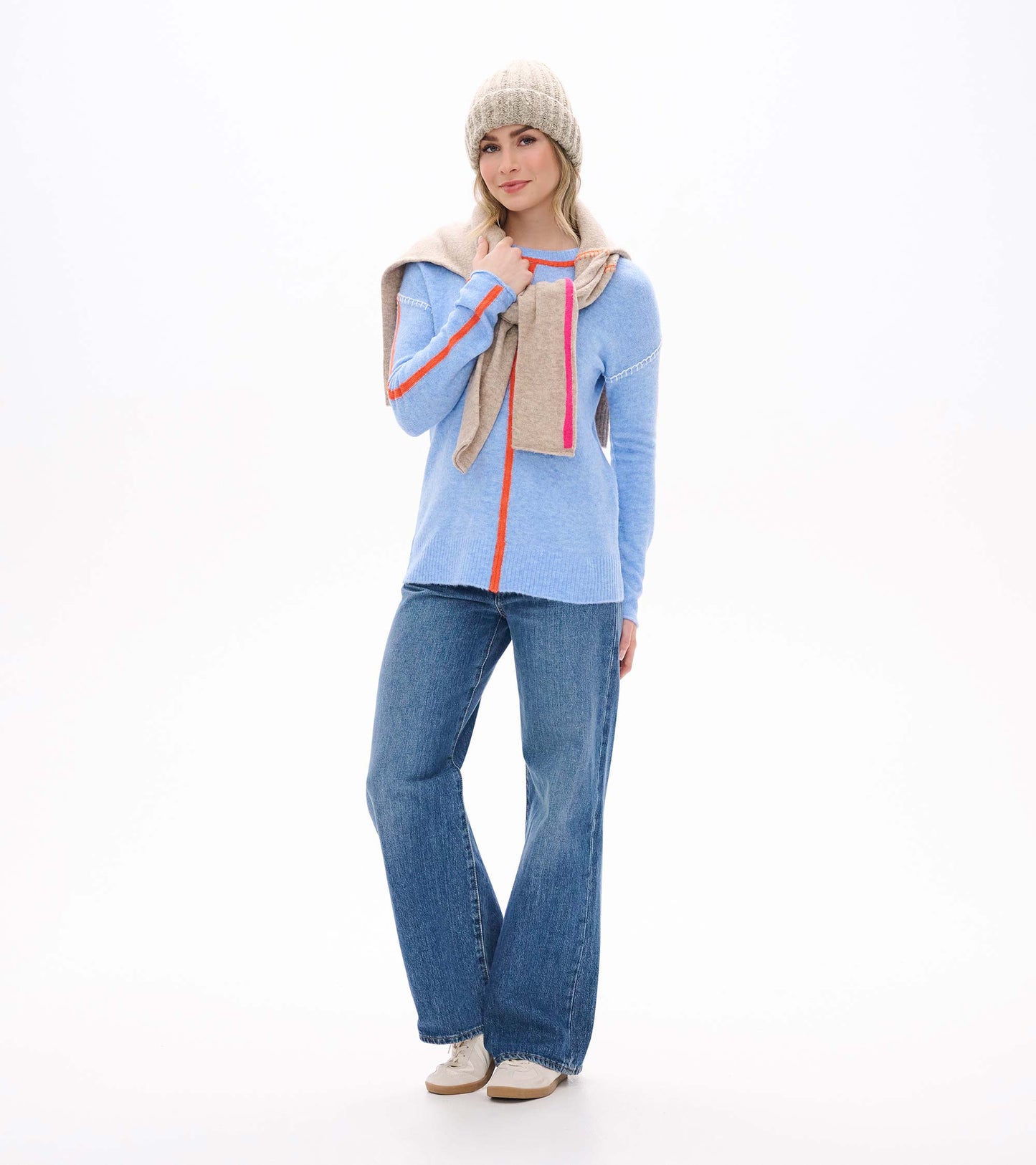 Maeve sweater in azure blue with orange trim, shown front view with jeans, scarf, and knit beanie