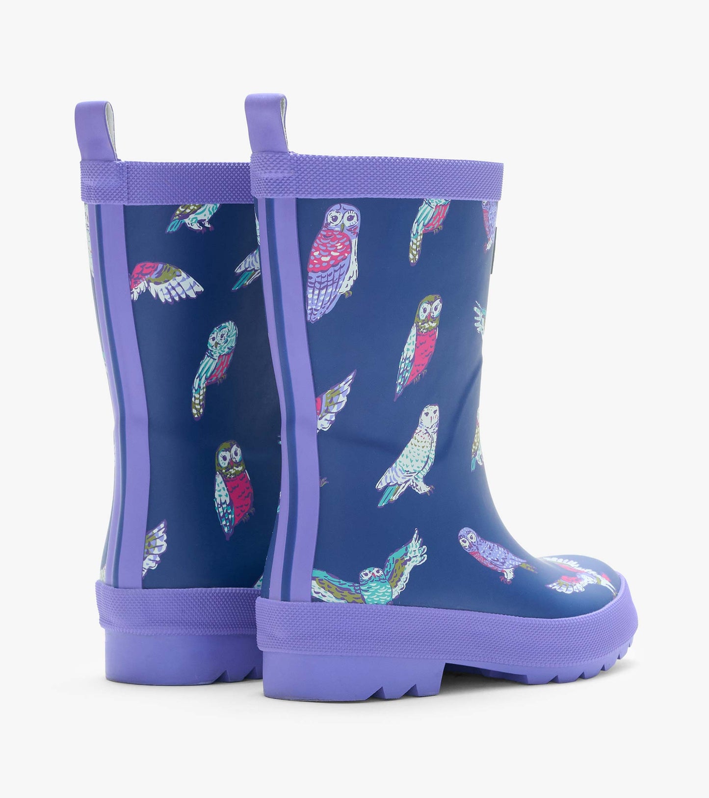 Rear side view of navy kids rain boots with colorful owl print, lavender trim, and back pull tabs
