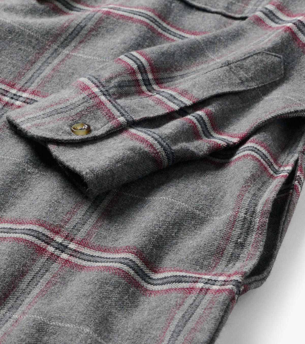 Close-up of gray plaid dress showing chest flap pocket, button detail, and brushed texture