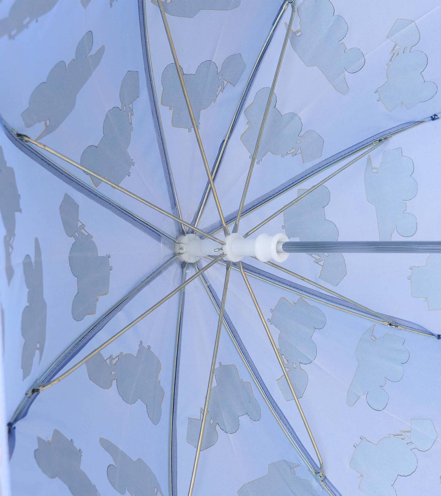 Interior view of blue umbrella showing metal ribs and pale construction vehicle silhouettes