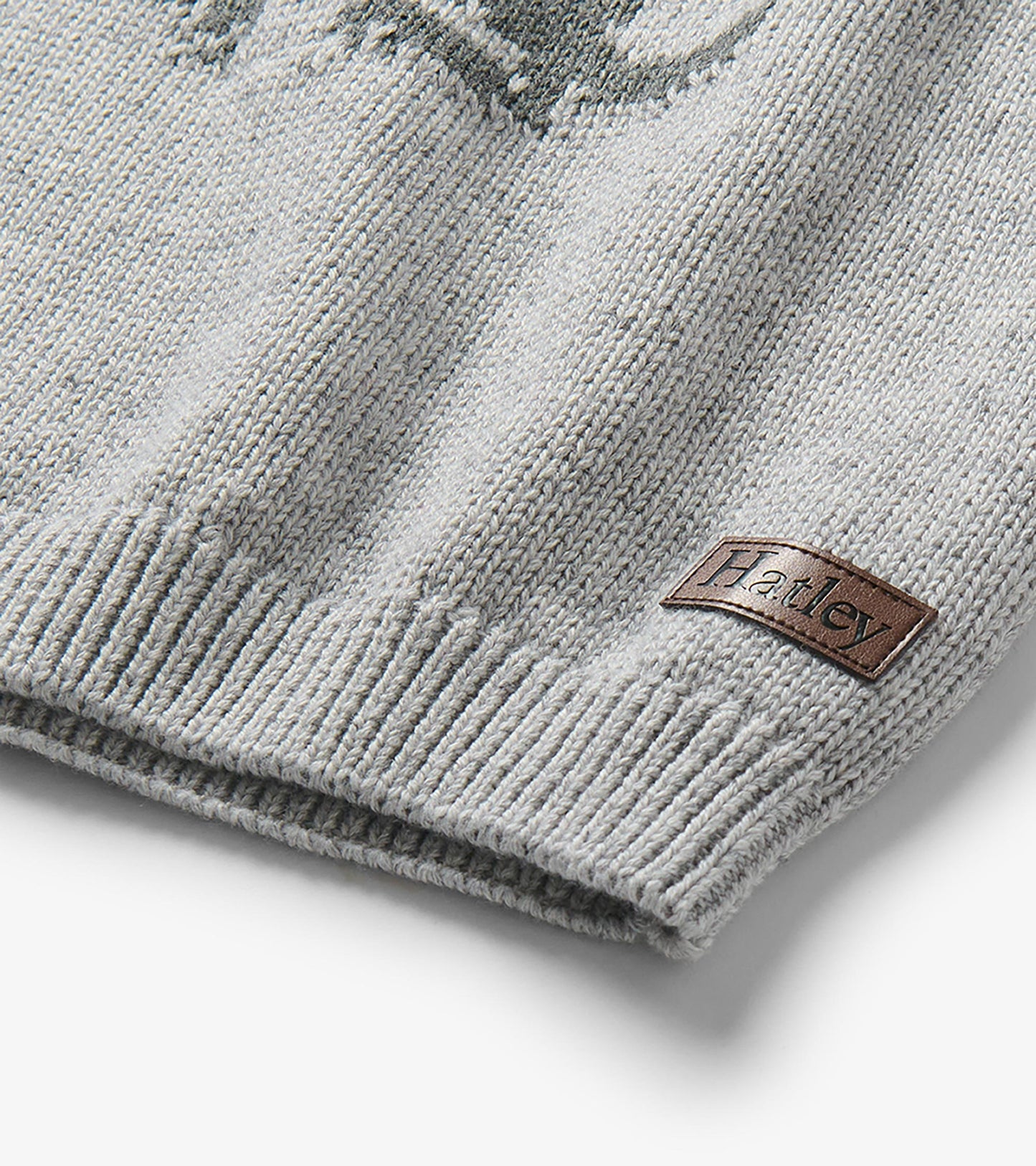 Close-up of the sweater hem with ribbed trim and a small Hatley patch