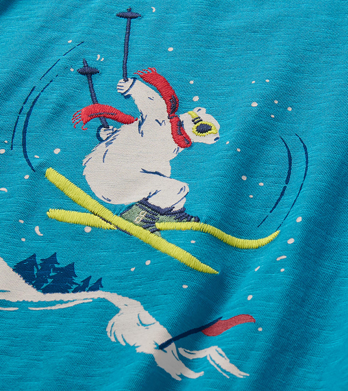 Close-up of bear graphic skiing in a red scarf and goggles on blue shirt