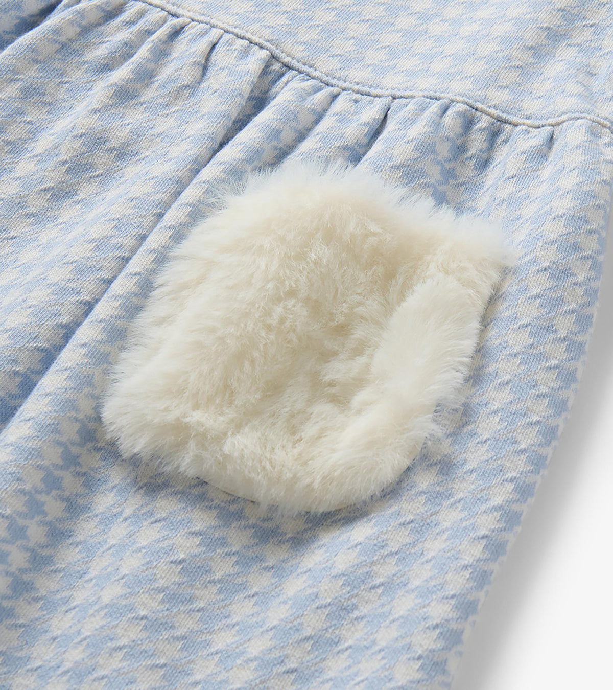 Close-up of white fur patch pocket on blue and white houndstooth dress