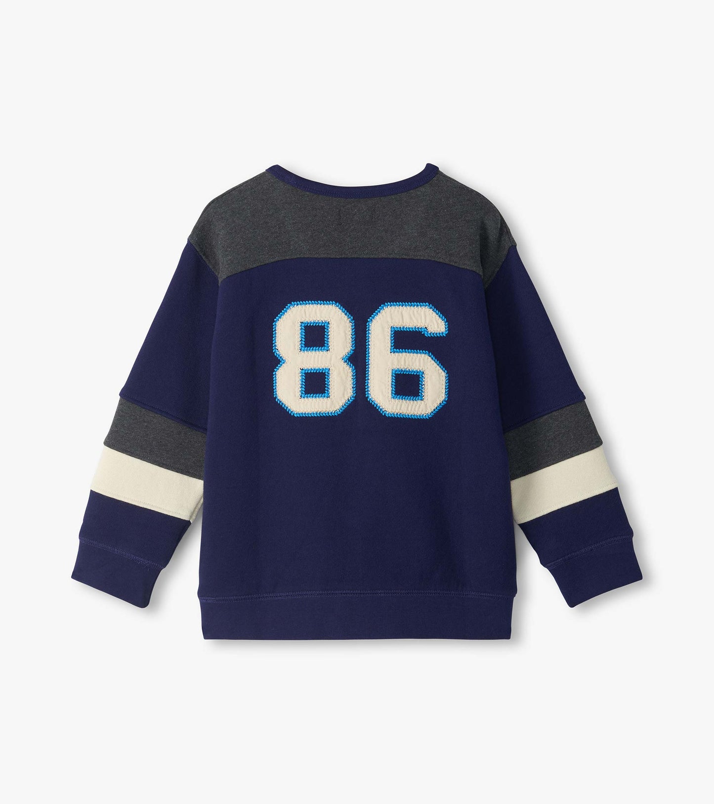 Back view of kids blue pullover top with gray yoke, cream sleeve stripes, and large 86 patch