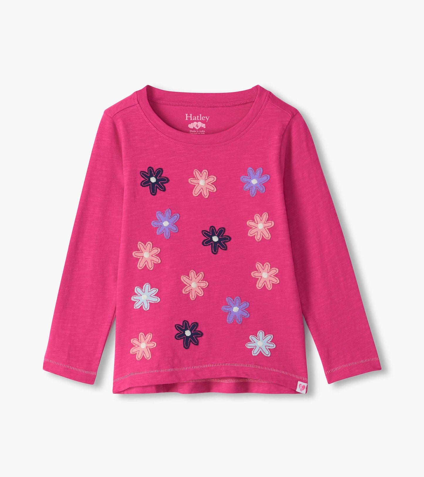Bright pink long sleeve tee with scattered flower graphics in navy, pink, light blue, and purple