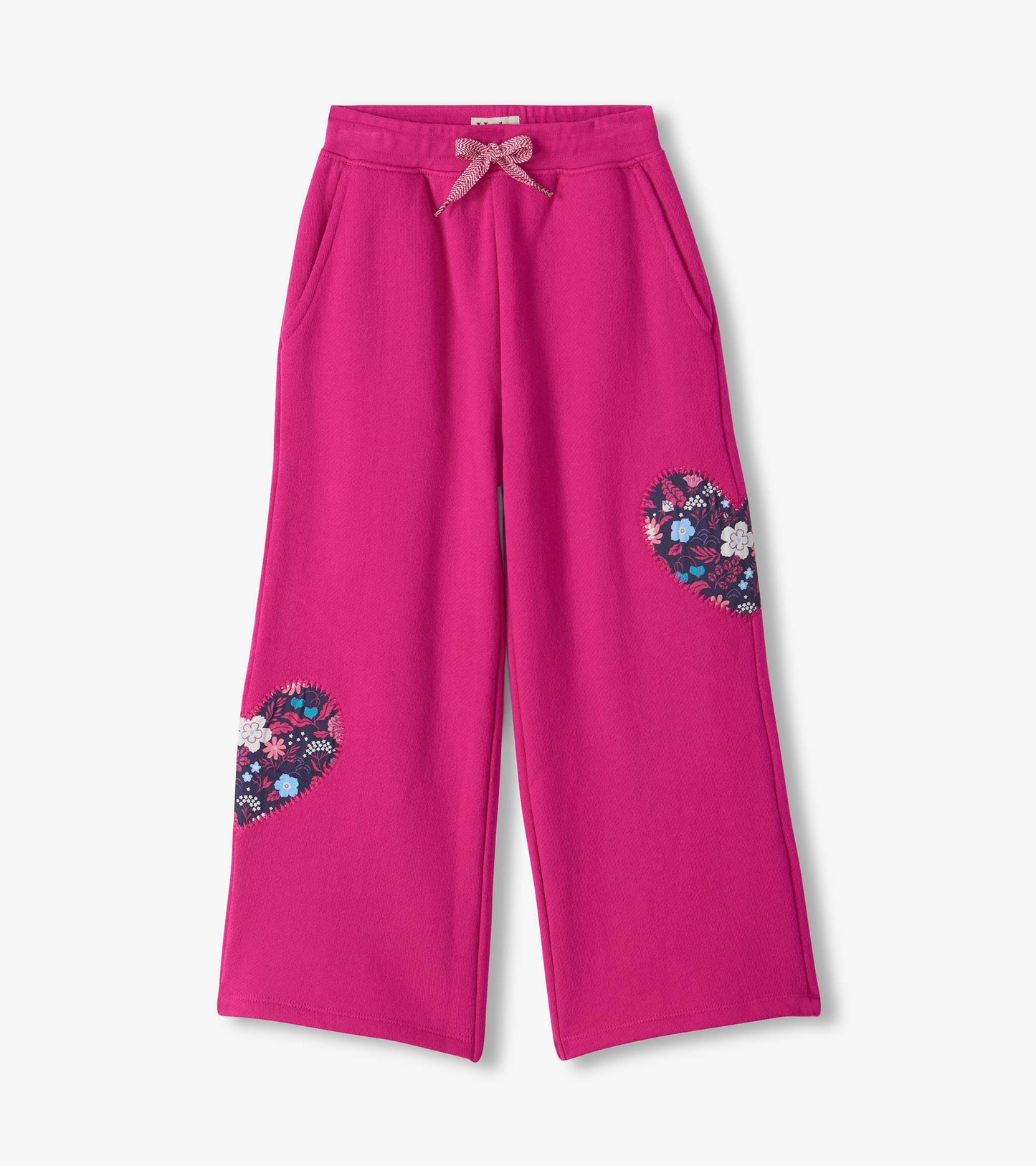 Berry pink wide leg track pants with side pockets, drawstring waist, and floral heart patches on the legs