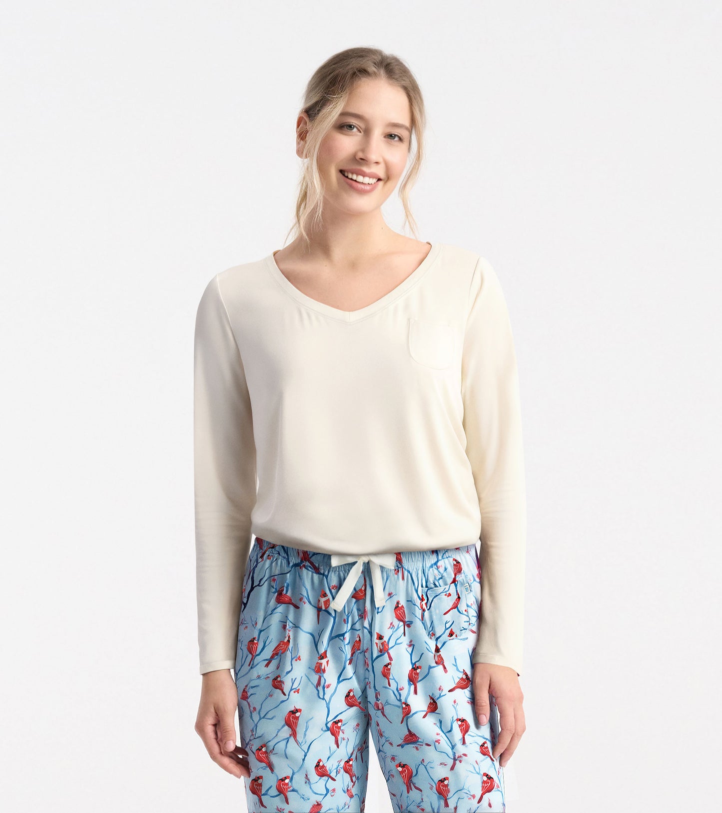 Cream long sleeve t-shirt with a v-neck and pocket, styled with patterned blue pajama pants.