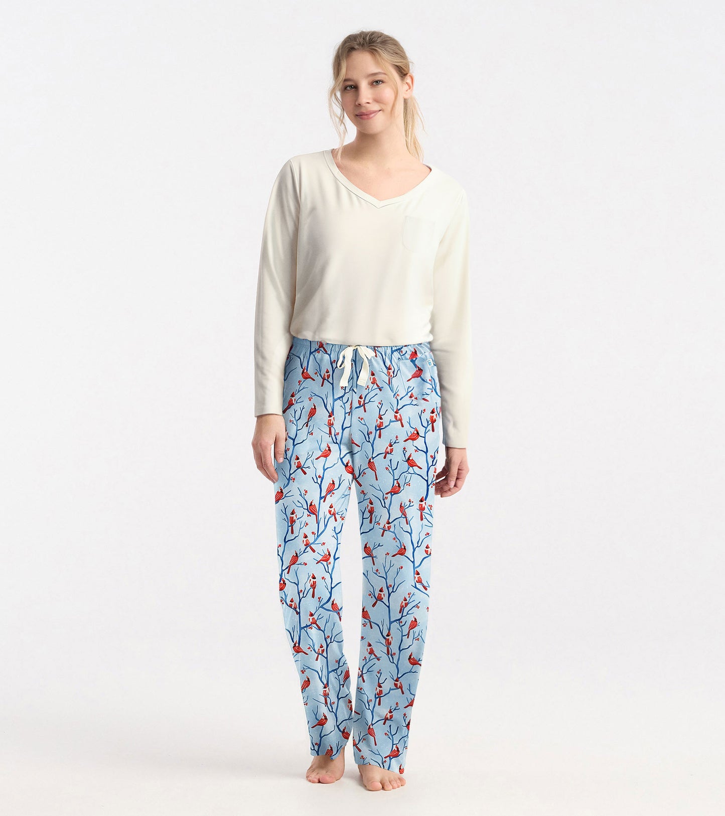 Cream long sleeve t-shirt with a v-neck and pocket, paired with patterned blue pajama pants featuring red birds.