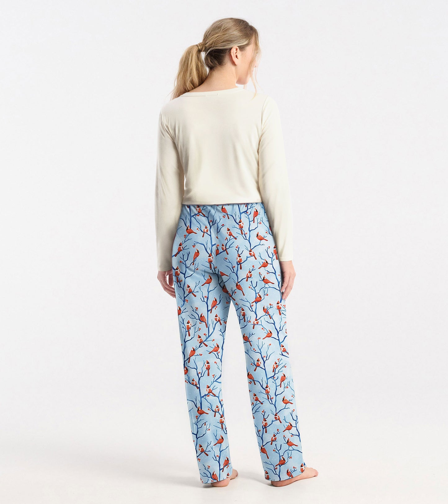 Cream long sleeve t-shirt with a relaxed fit, paired with patterned blue pajama pants featuring bird designs.