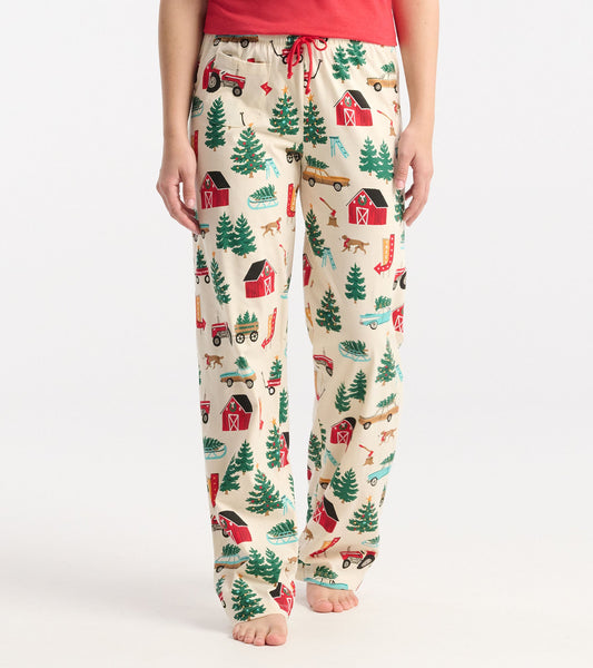 Cream cotton pajama pants featuring a festive Christmas tree farm print with barns, tractors, and trees.