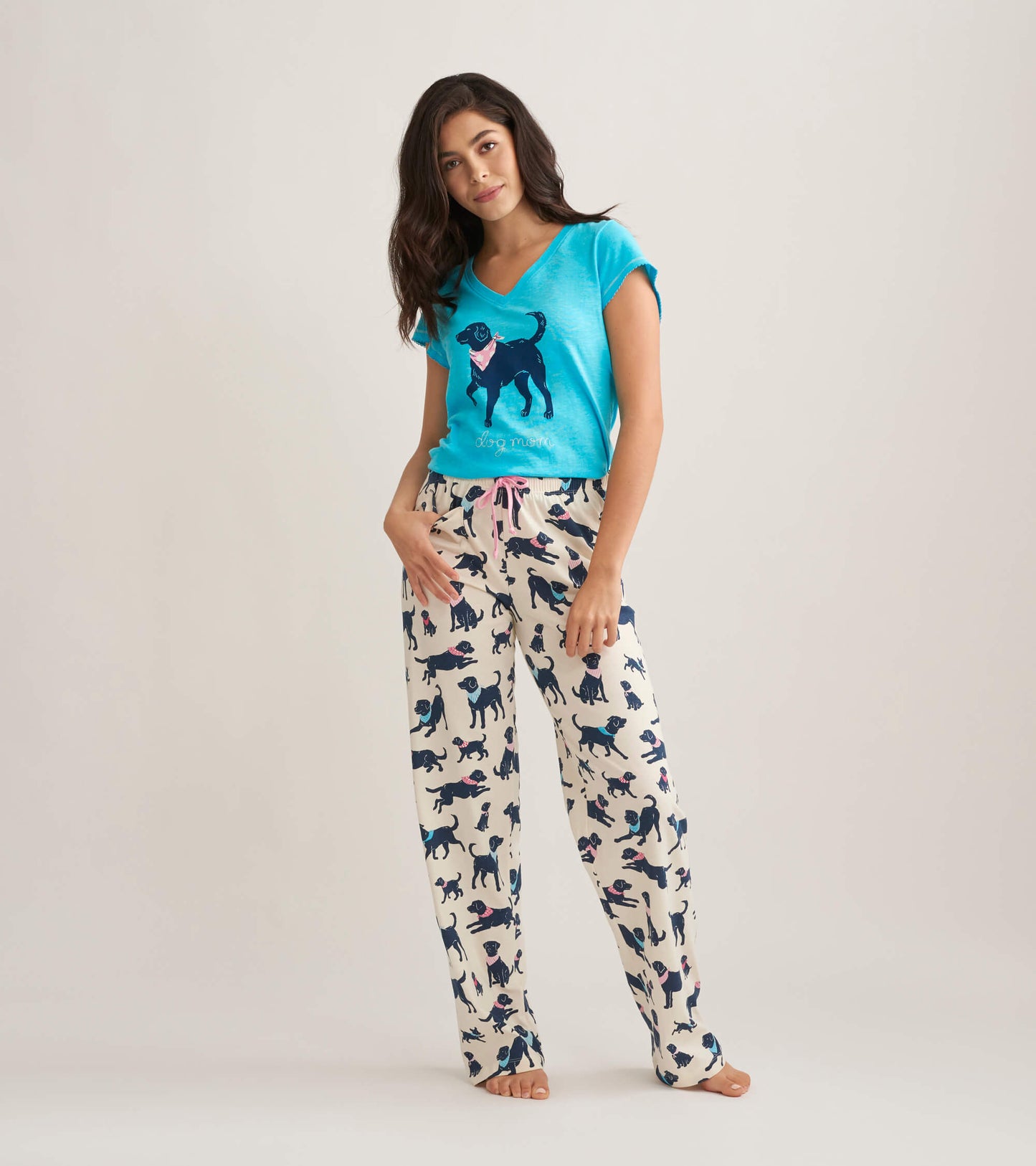 Women's cotton pajama pants featuring a playful dog print on a cream background with a pink drawstring.