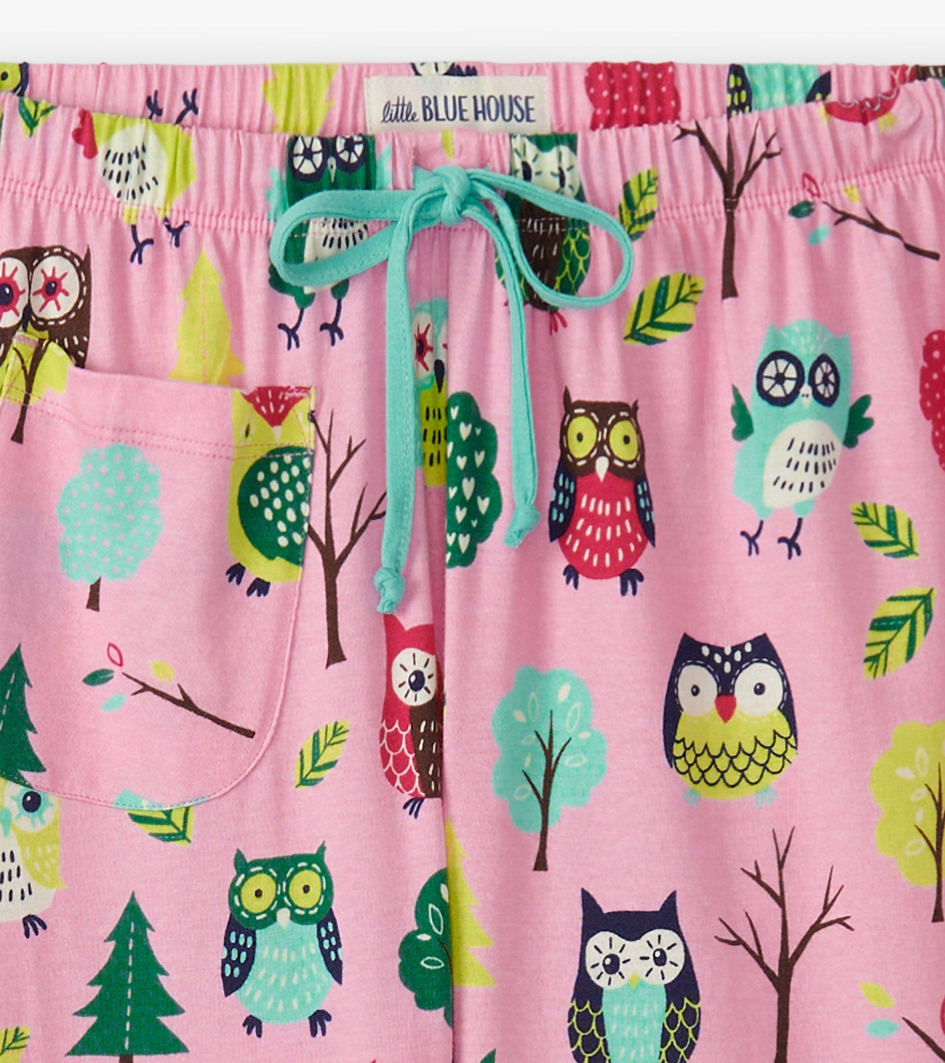 Pink cotton pajama pants featuring a colorful owl and tree pattern, with an elastic waistband and drawstring.