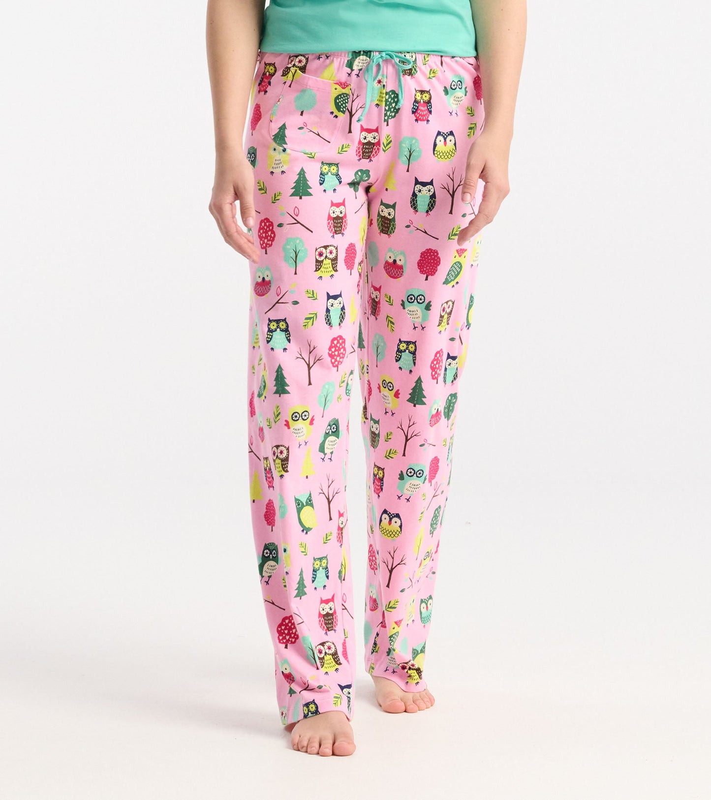 Pink cotton pajama pants featuring a colorful owl and tree pattern, with an elastic waistband and drawstring.