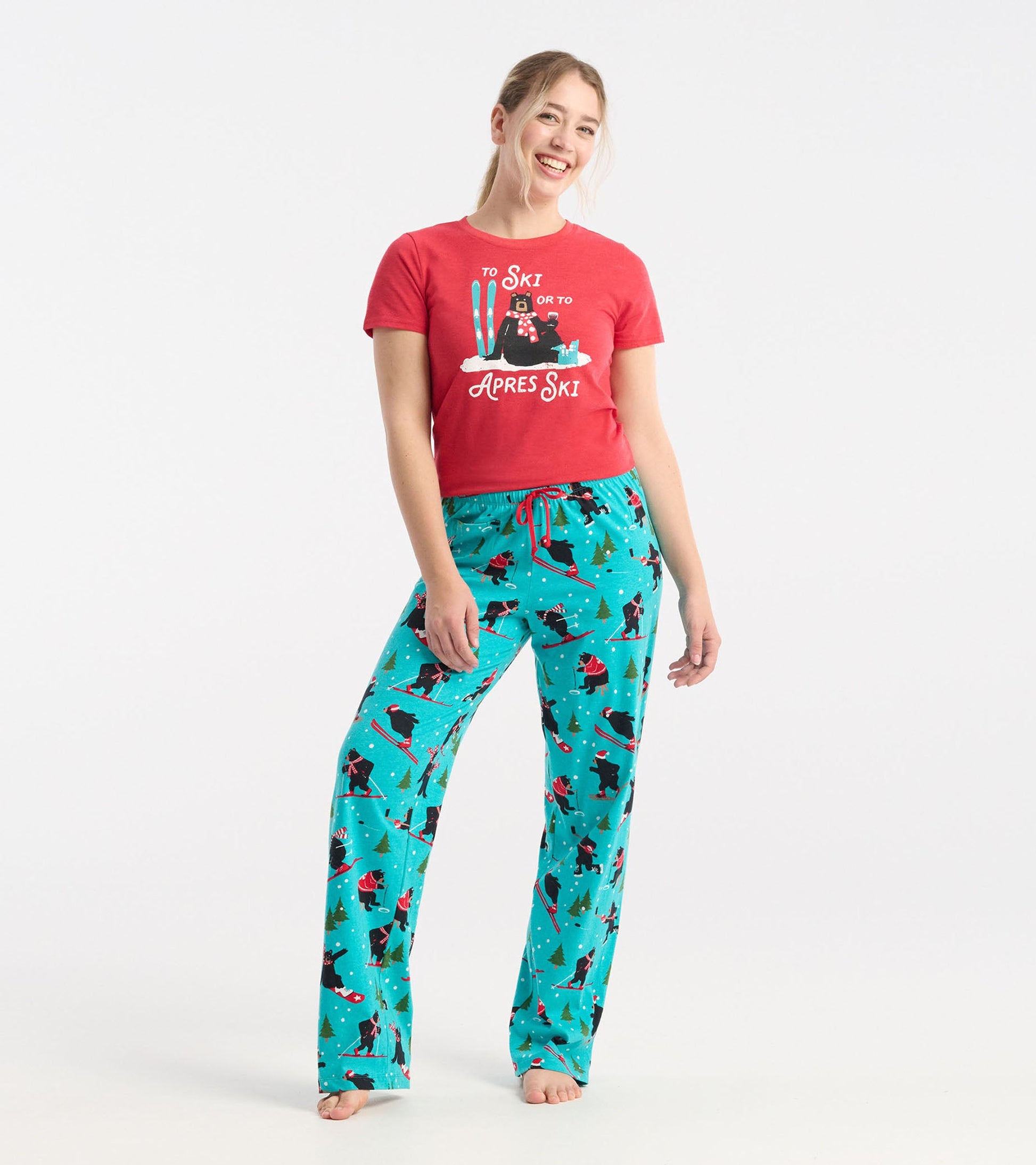 Turquoise cotton pajama pants with a winter sports pattern, featuring skiers and trees, styled with an elastic waistband.