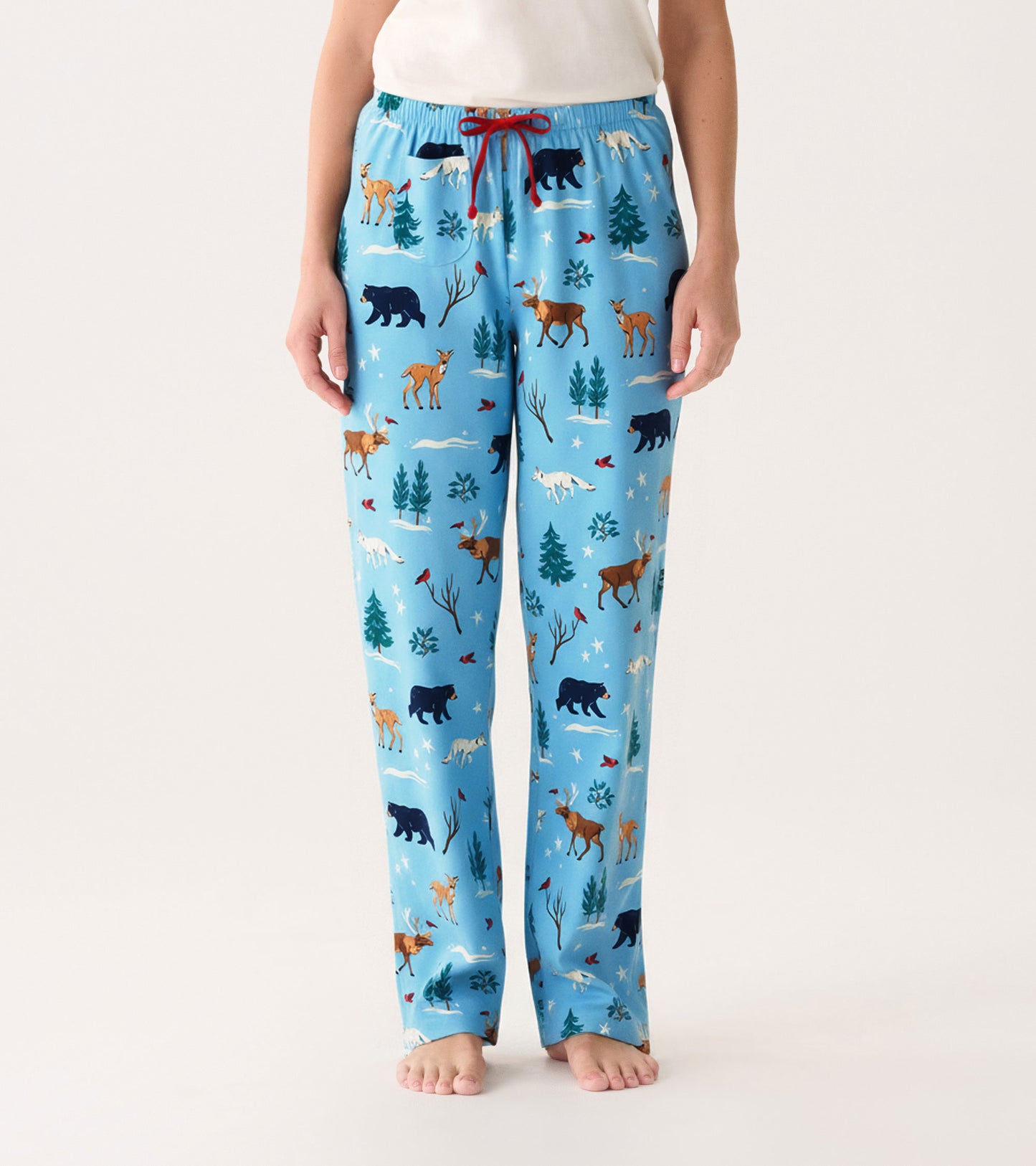 Light blue cotton pajama pants featuring a winter wildlife pattern with bears, deer, and trees, finished with a red drawstri…
