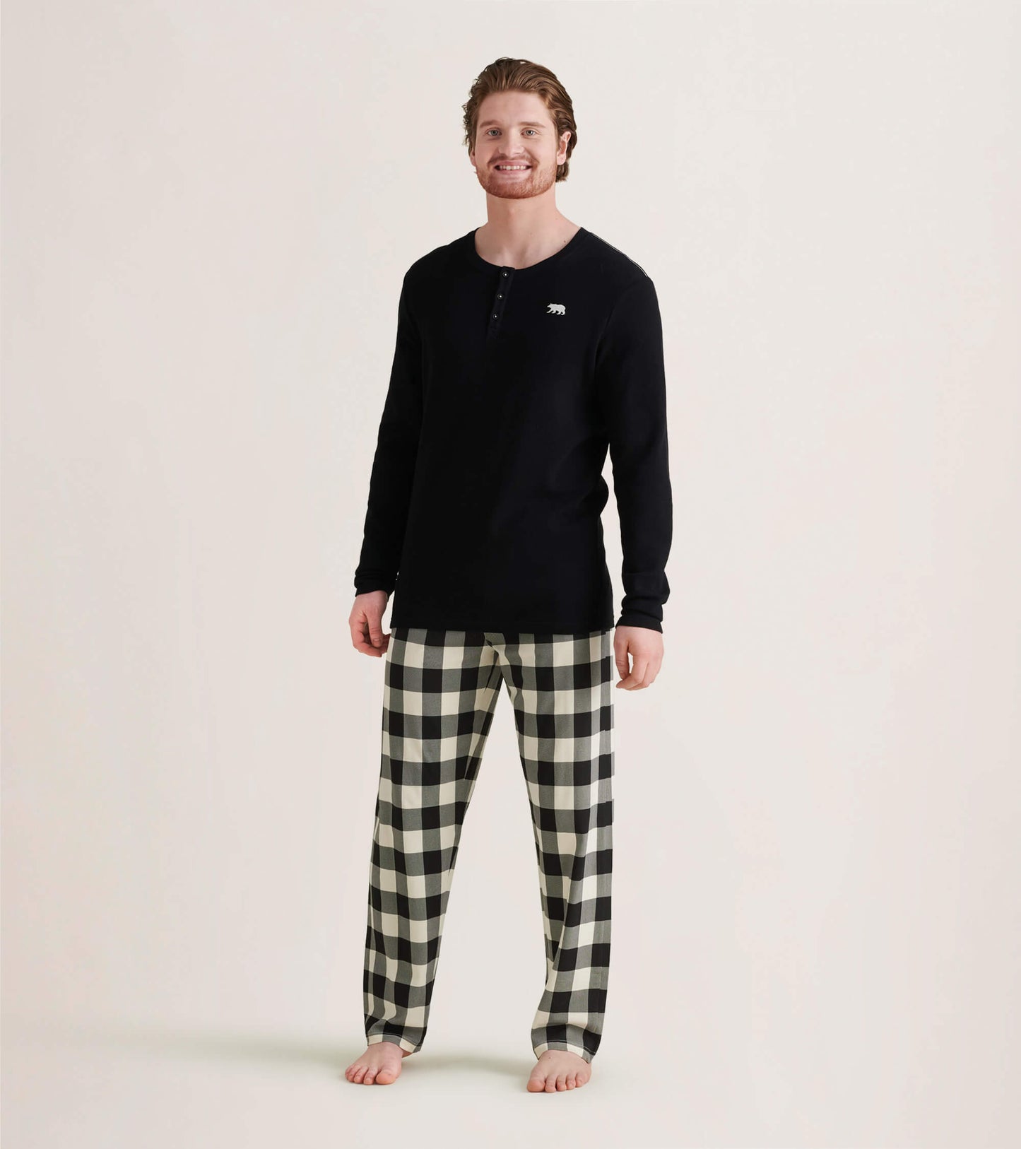 Cream plaid men's stretch cotton pajama pants, featuring a relaxed fit and elastic waistband, worn with a black long-sleeve…