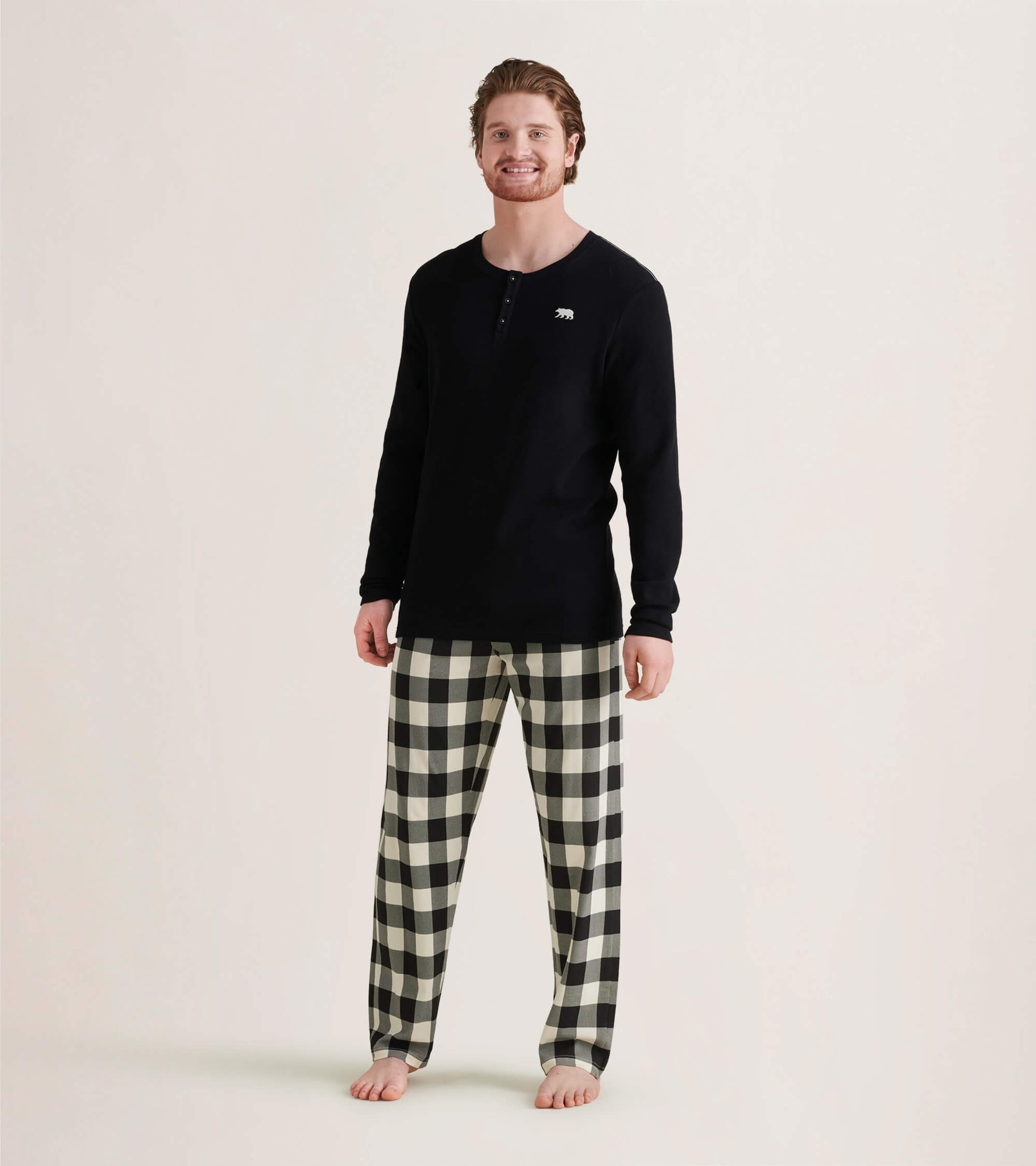 Cream plaid men's stretch cotton pajama pants, featuring a relaxed fit and elastic waistband, worn with a black long-sleeve…