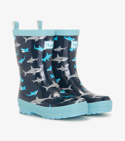 Navy rain boots featuring a shark pattern, with a light blue sole and trim, designed for kids.