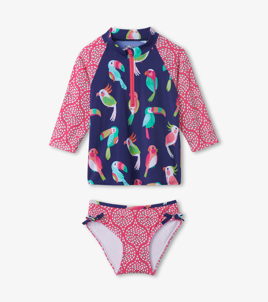 Navy rashguard set featuring colorful tropical birds, with a pink patterned bikini bottom and long sleeves.