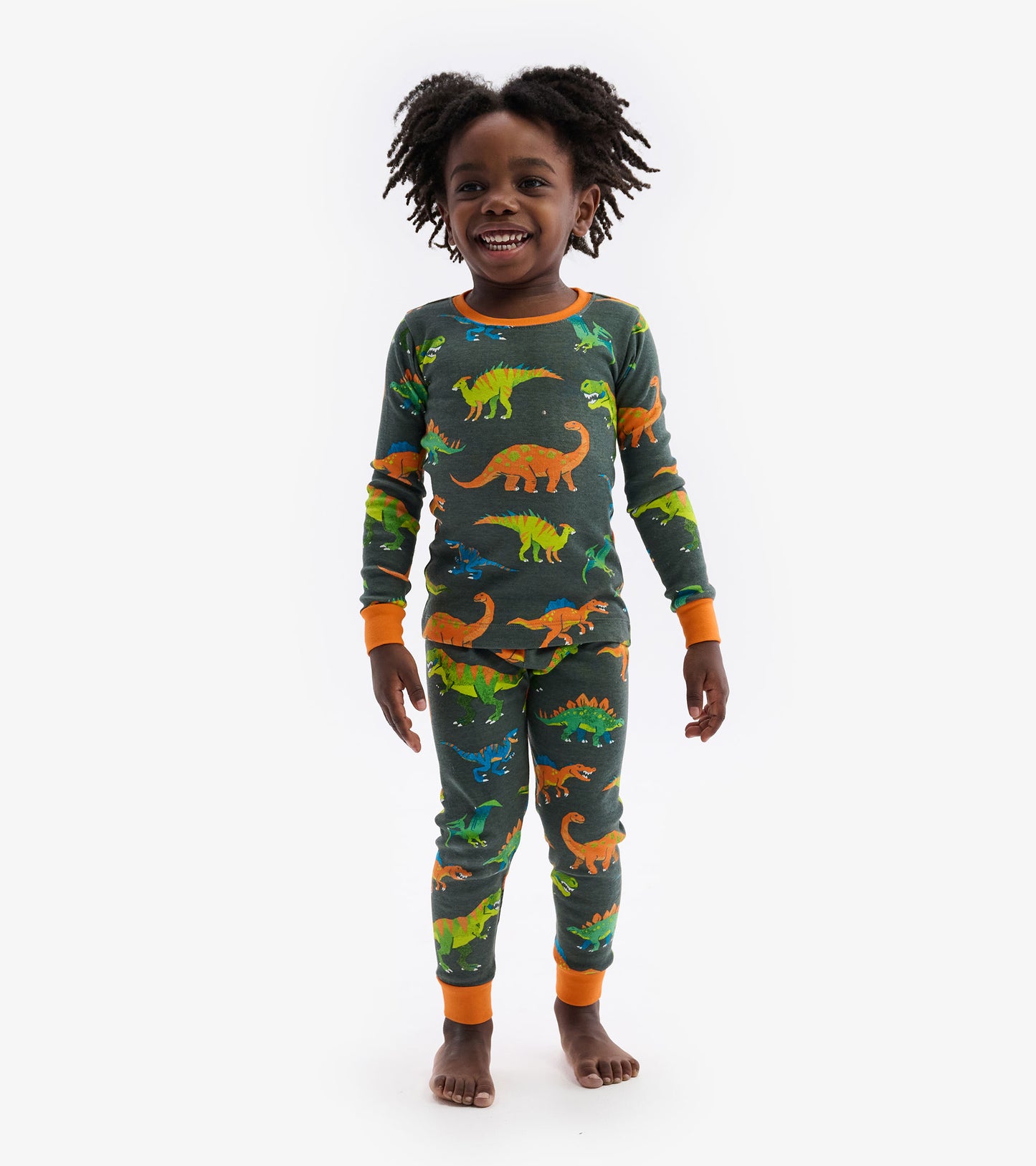 Green dinosaur-patterned pajama set with orange cuffs, featuring a long-sleeve top and matching pants.