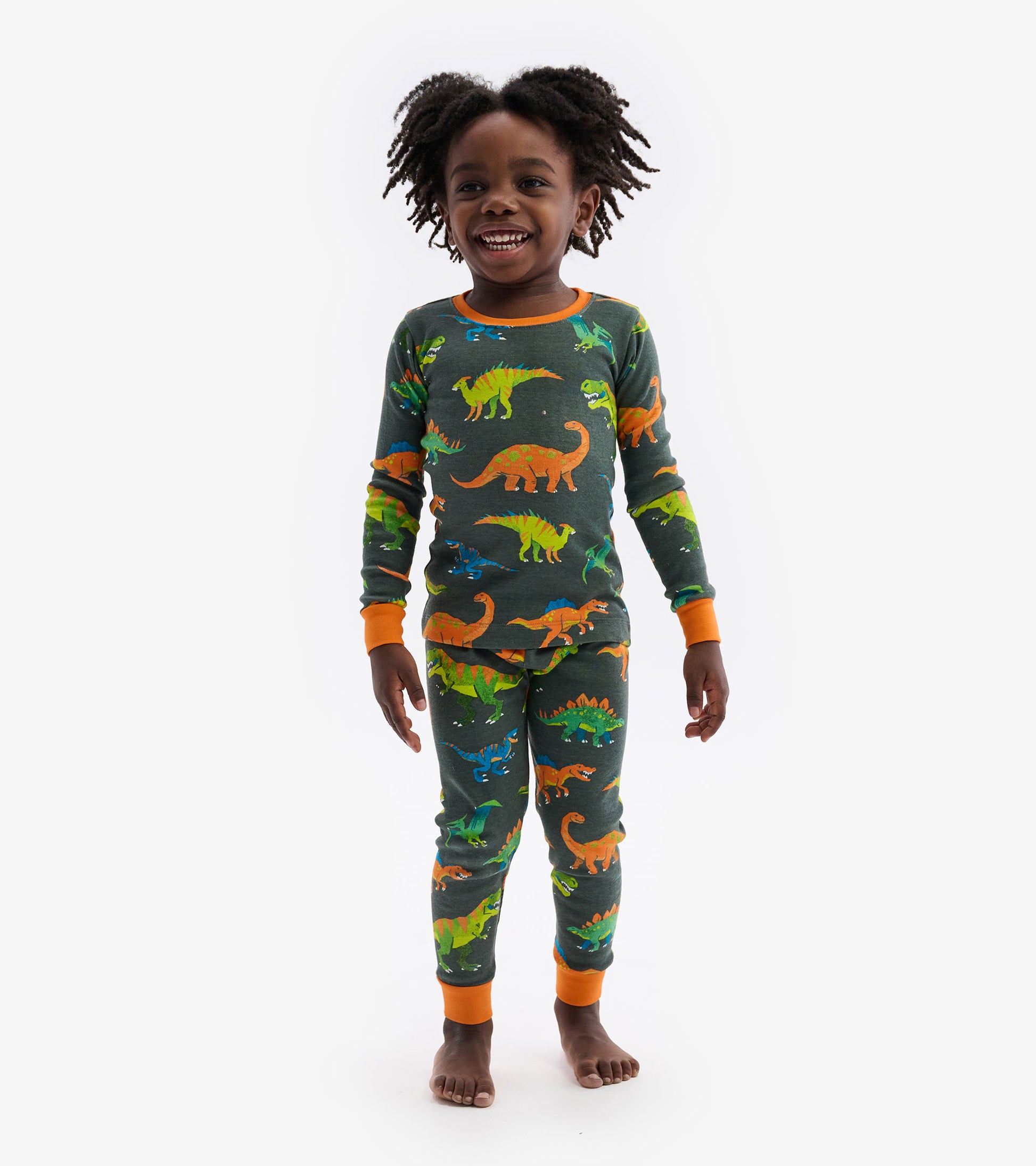 Green dinosaur-patterned pajama set with orange cuffs, featuring a long-sleeve top and matching pants.