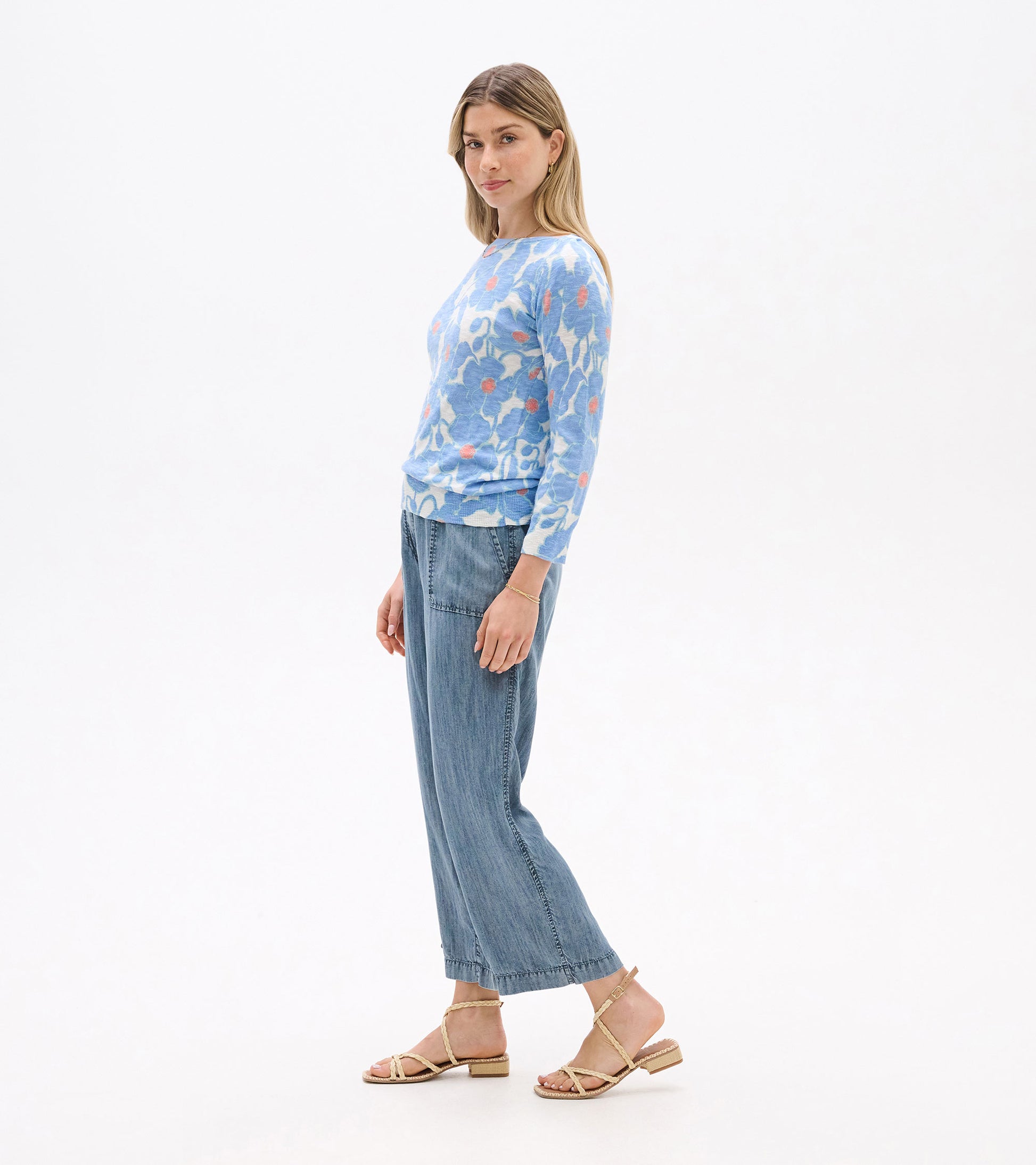 Light blue 3/4 sleeve knit top with textured poppy pattern, paired with light denim pants and sandals.