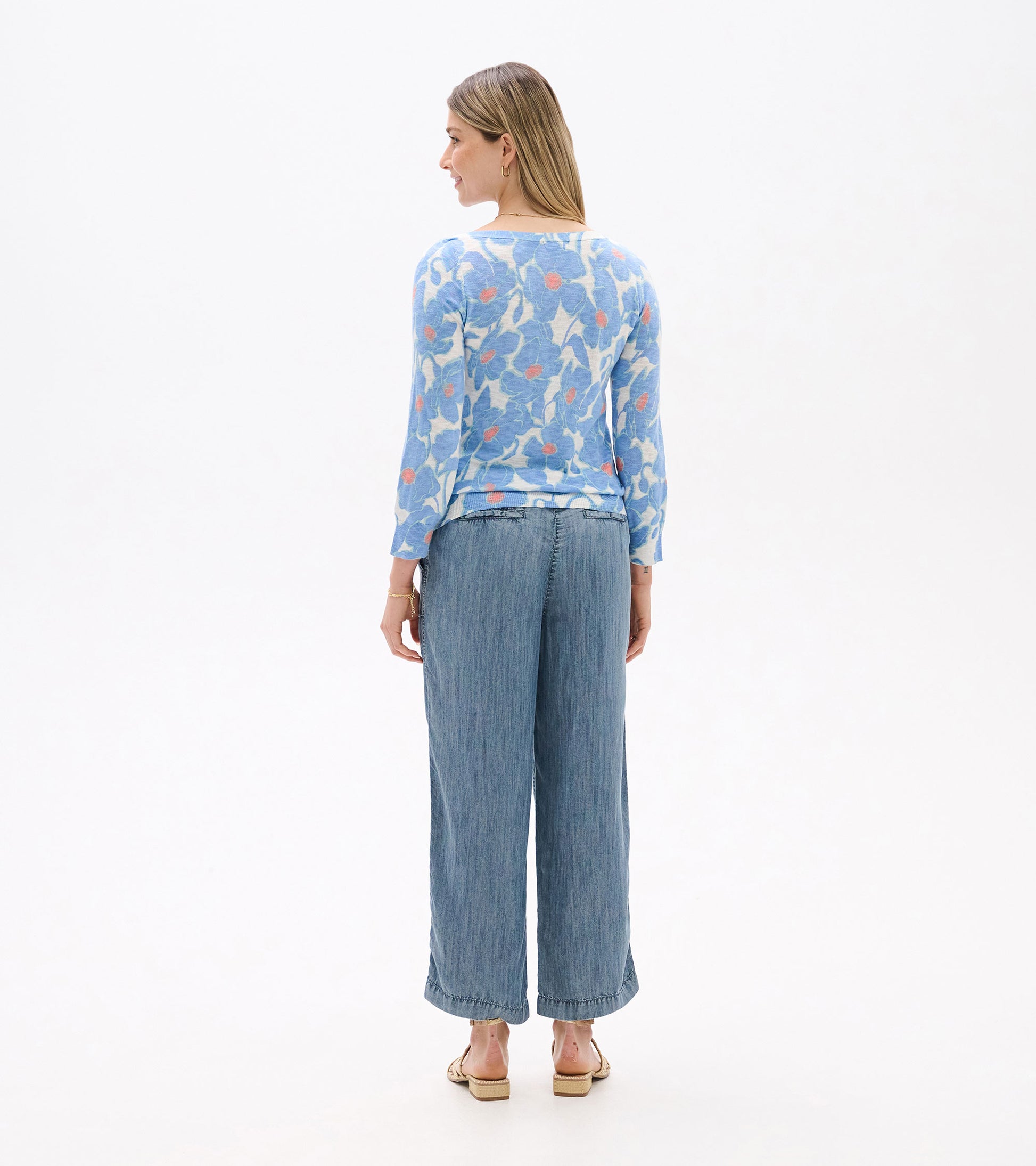 Light blue 3/4 sleeve knit top with textured poppy pattern, paired with wide-leg denim pants.