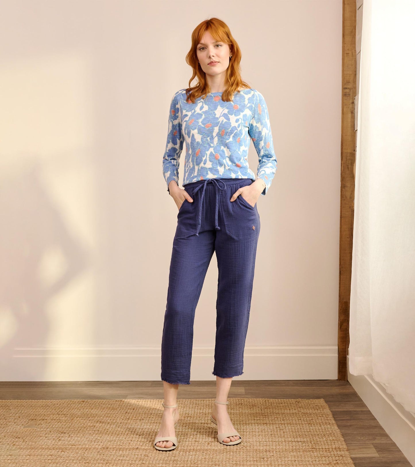 Full-length front view of blue poppy print knit Breton top styled with blue drawstring pants