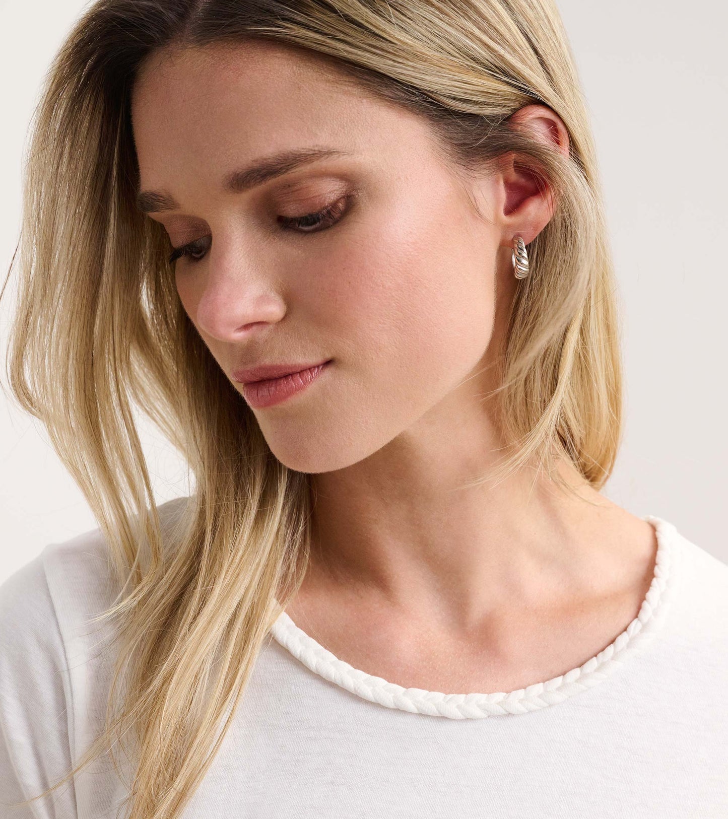 White braided neck tee featuring a relaxed fit and soft fabric, styled on a model with long hair.
