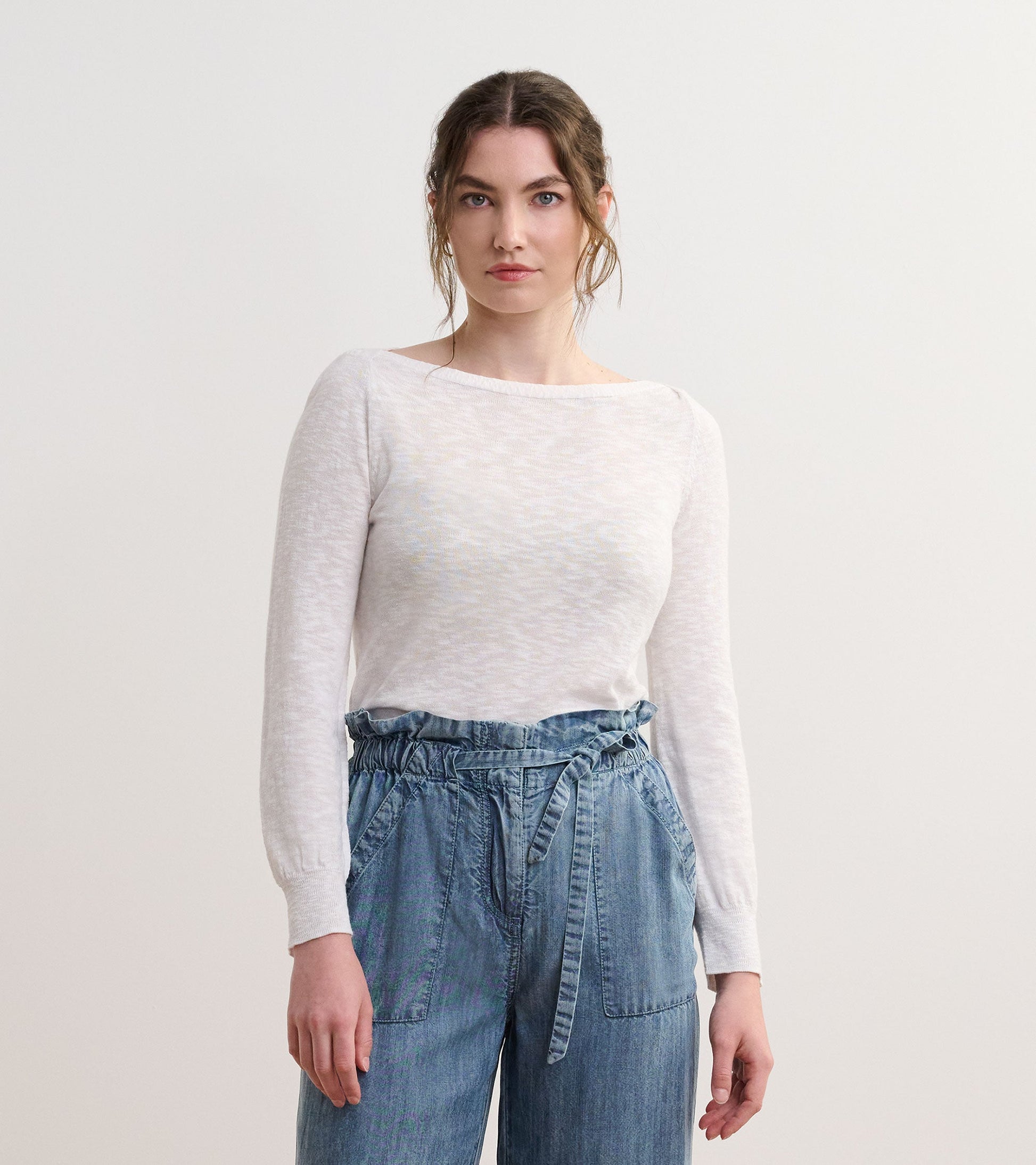 White 3/4 sleeve knit top with a relaxed fit, paired with light blue denim pants.