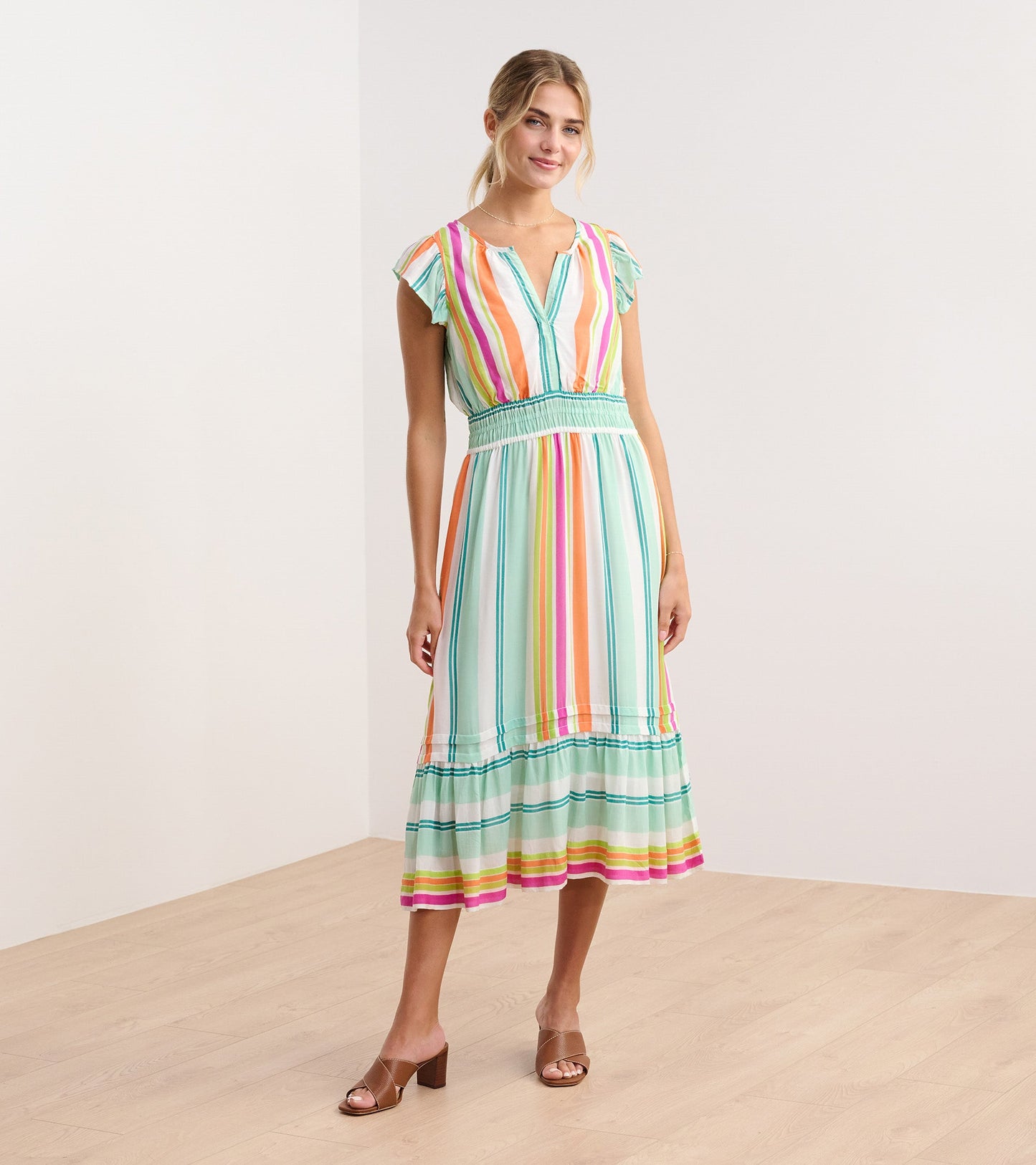Lightweight midi dress in sea glass with colorful vertical stripes, featuring a smocked waist and flutter sleeves.